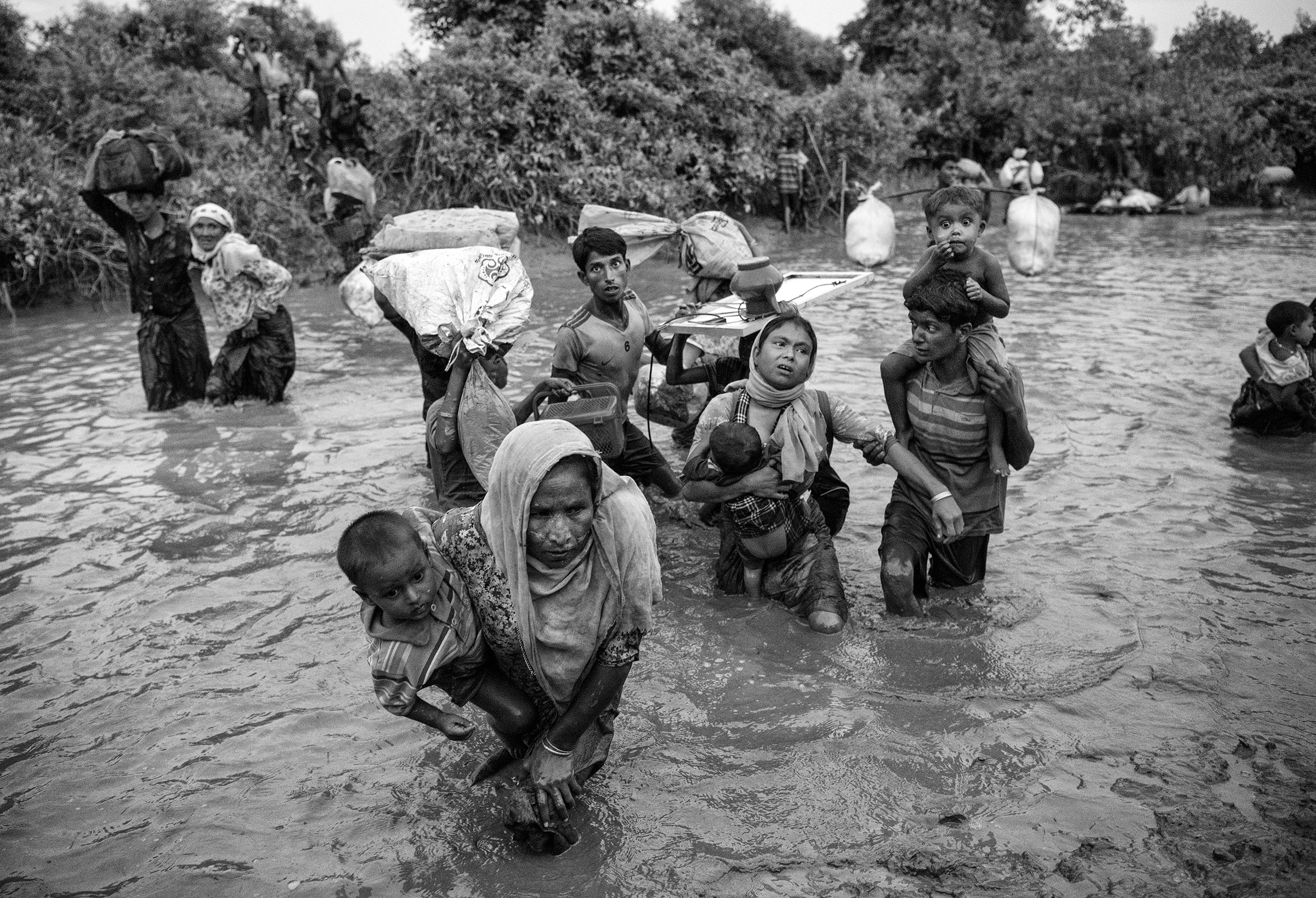 Rohingya Muslim refugees cross a canal as they flee over the border from Myanmar into Bangladesh at the Naf River on Nov. 1, 2017 near Anjuman Para in Cox's Bazar, Bangladesh.