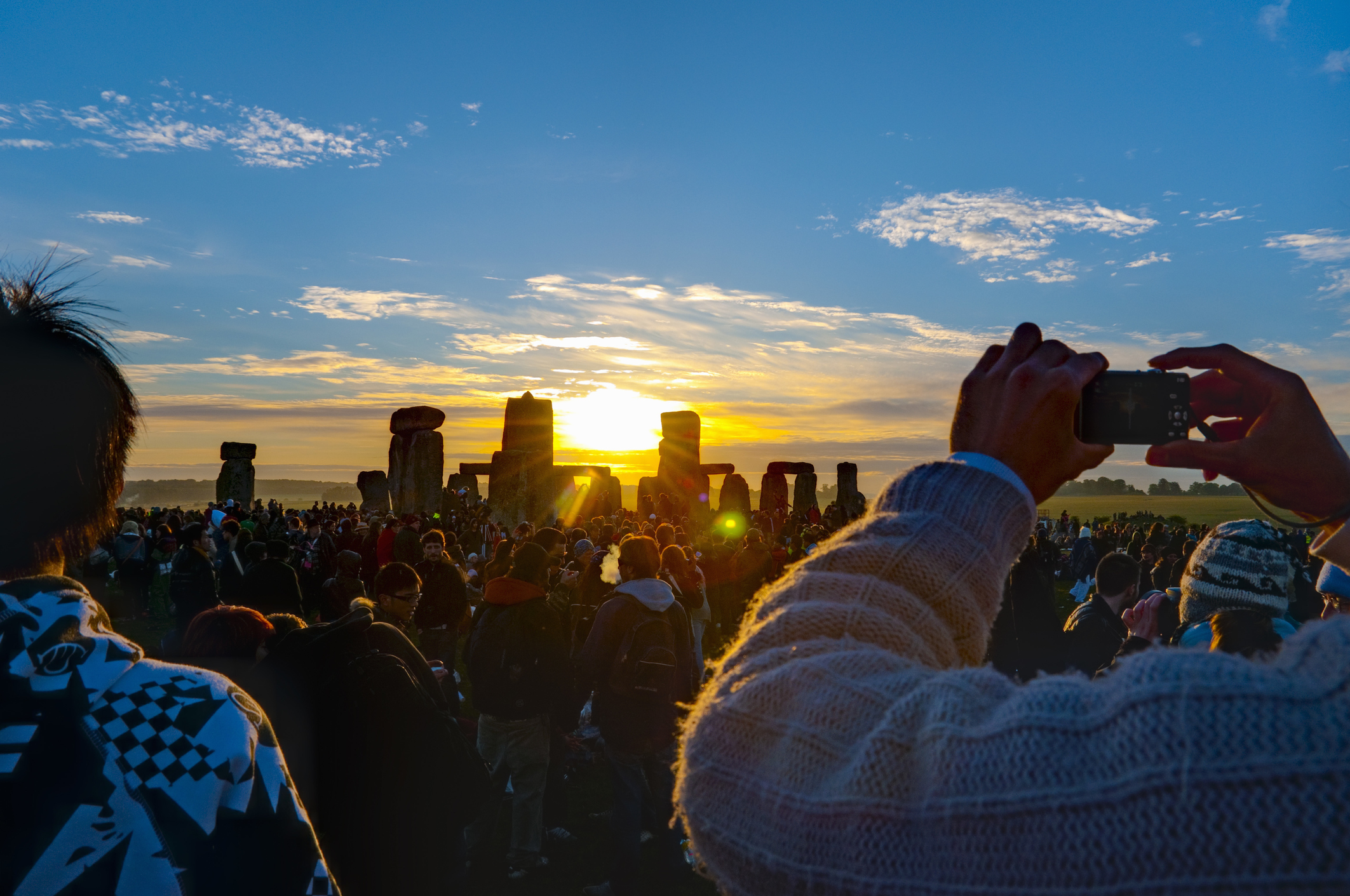 Visitors take photos of the sunrise at Stonehenge in Wiltshire, England. (Alan Copson—AWL Images/Getty Images)