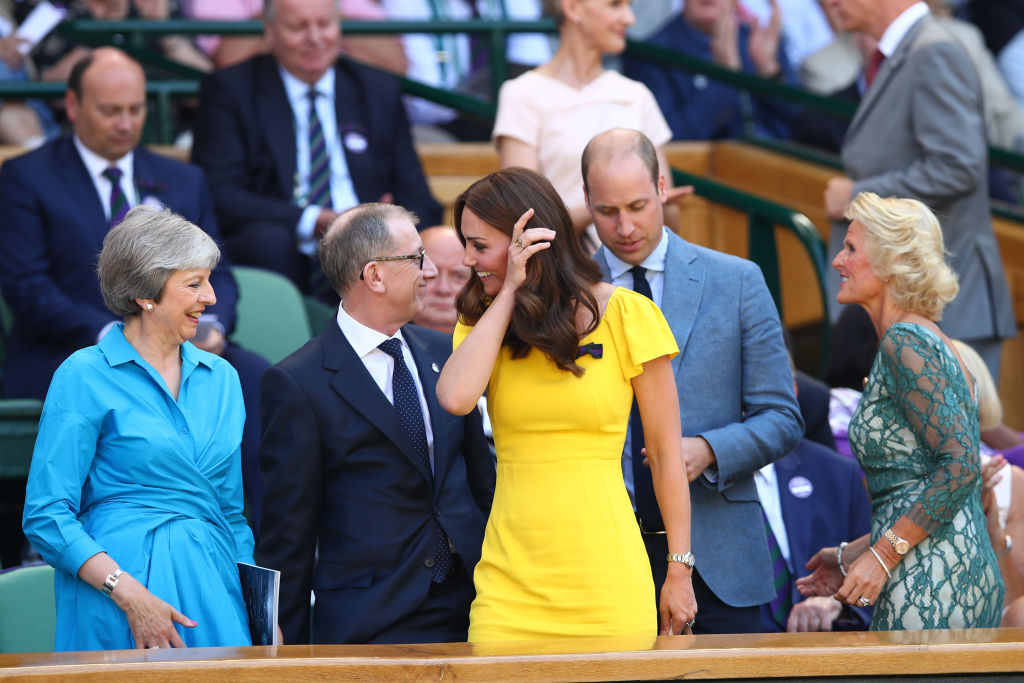 Catherine, Duchess of Cambridge and Prince William, Duke of Cambridge pass British Prime Minister Theresa May and her husband Philip May as they attend the Men's Singles final on day thirteen of the Wimbledon Lawn Tennis Championships at All England Lawn Tennis and Croquet Club on July 15, 2018 in London, England. (Clive Brunskill—Getty Images)