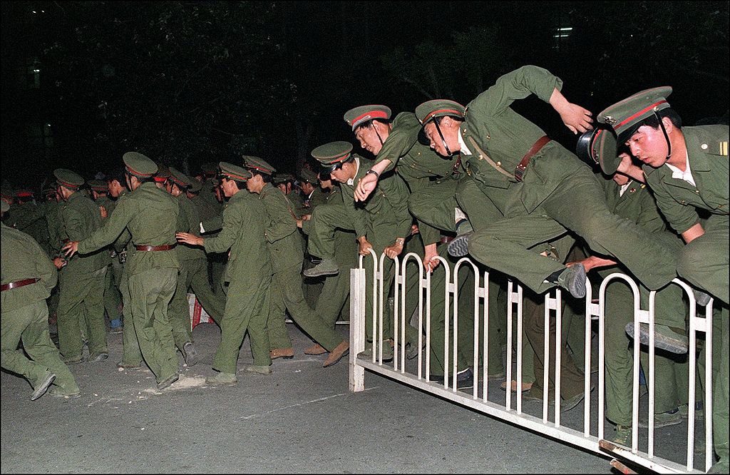 People's Liberation Army (PLA) soldiers leap over a barrier on Tiananmen Square in central Beijing June 4, 1989. (Catherine Henriette—AFP/Getty Images)