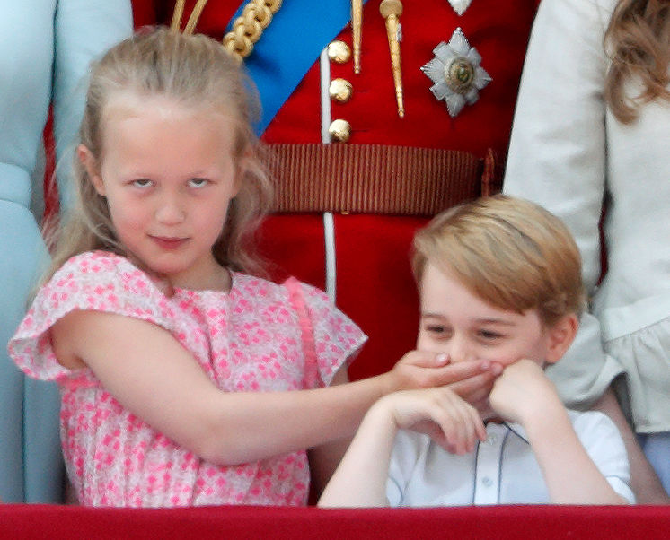 Savannah Phillips puts her hand over Prince George of Cambridge's mouth as they stand on the balcony of Buckingham Palace during Trooping The Colour 2018 on June 9, 2018 in London, England. (Max Mumby—Indigo/Getty Images)