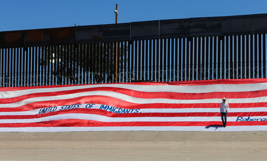 Mexican U.S. resident Roberto Márquez, places a United States national flag on the border wall next to Rio Grande river to demonstrate against the immigration policies of Donald Trump in the border between El Paso, US, and Ciudad Juarez, Mexico, on June 6, 2019. (HERIKA MARTINEZ&mdash;AFP/Getty Images)