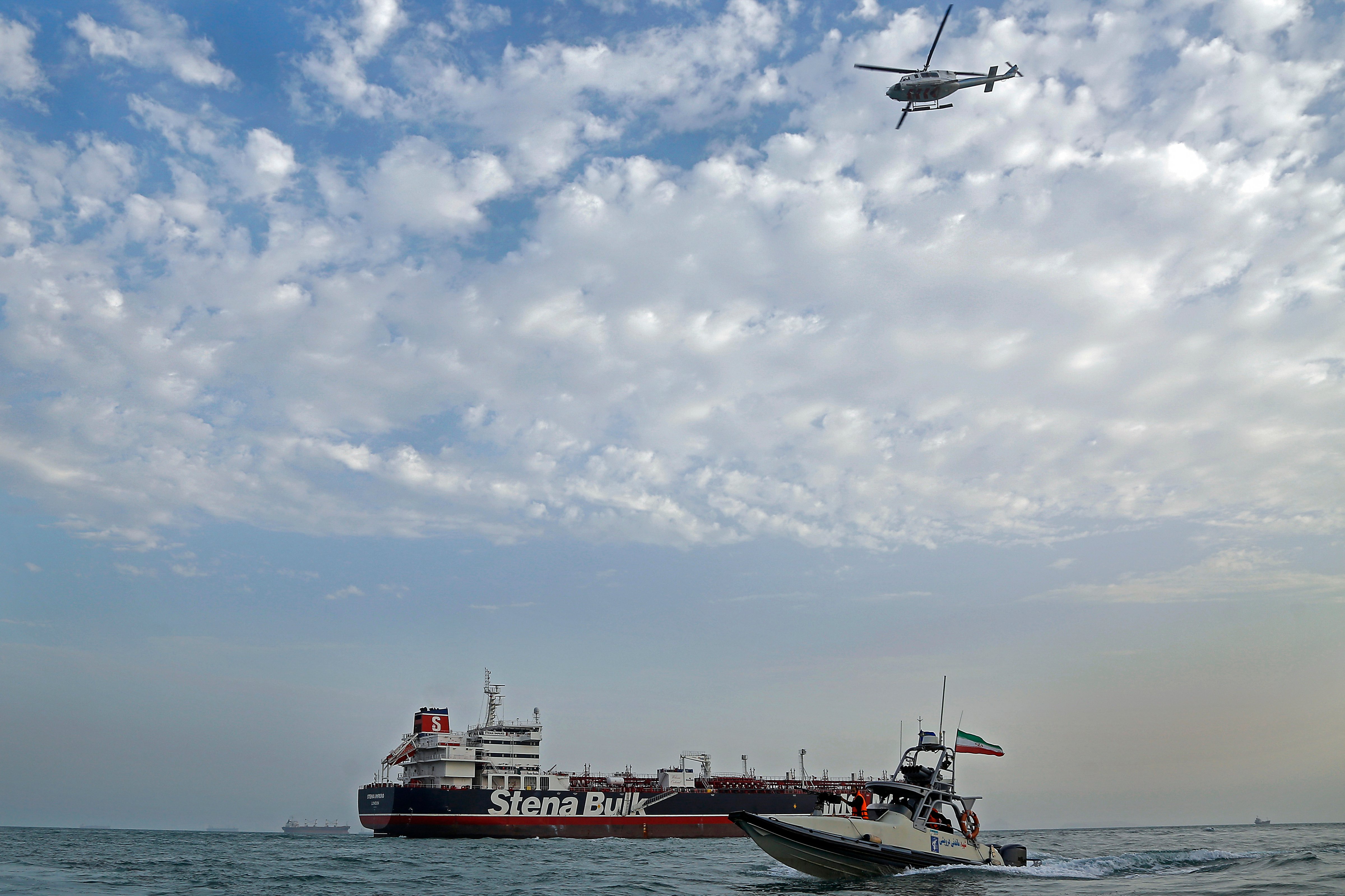 A speedboat and a helicopter of Iran's Revolutionary Guard move around a British-flagged oil tanker MV Stena Impero on July 21, 2019, after it was seized by Iran in the Persian Gulf (Hasan Shirvani—AP)