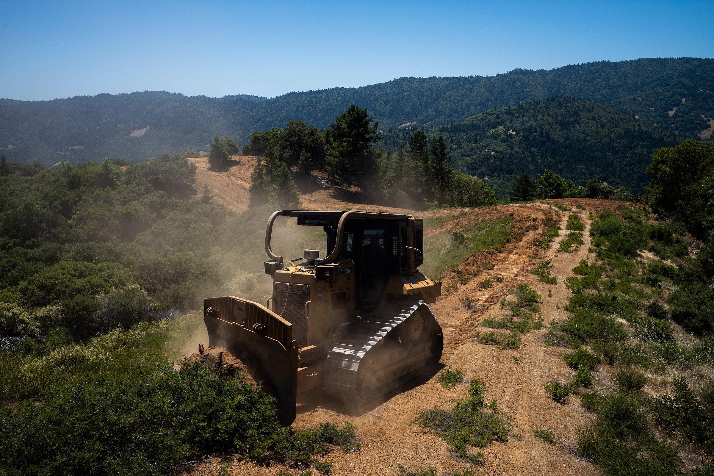 A bulldozer works on a firebreak, a gap in vegetation that acts as a barrier to slow the progress of a wildfire, in the hills surrounding Ukiah. (Brian L. Frank for TIME)