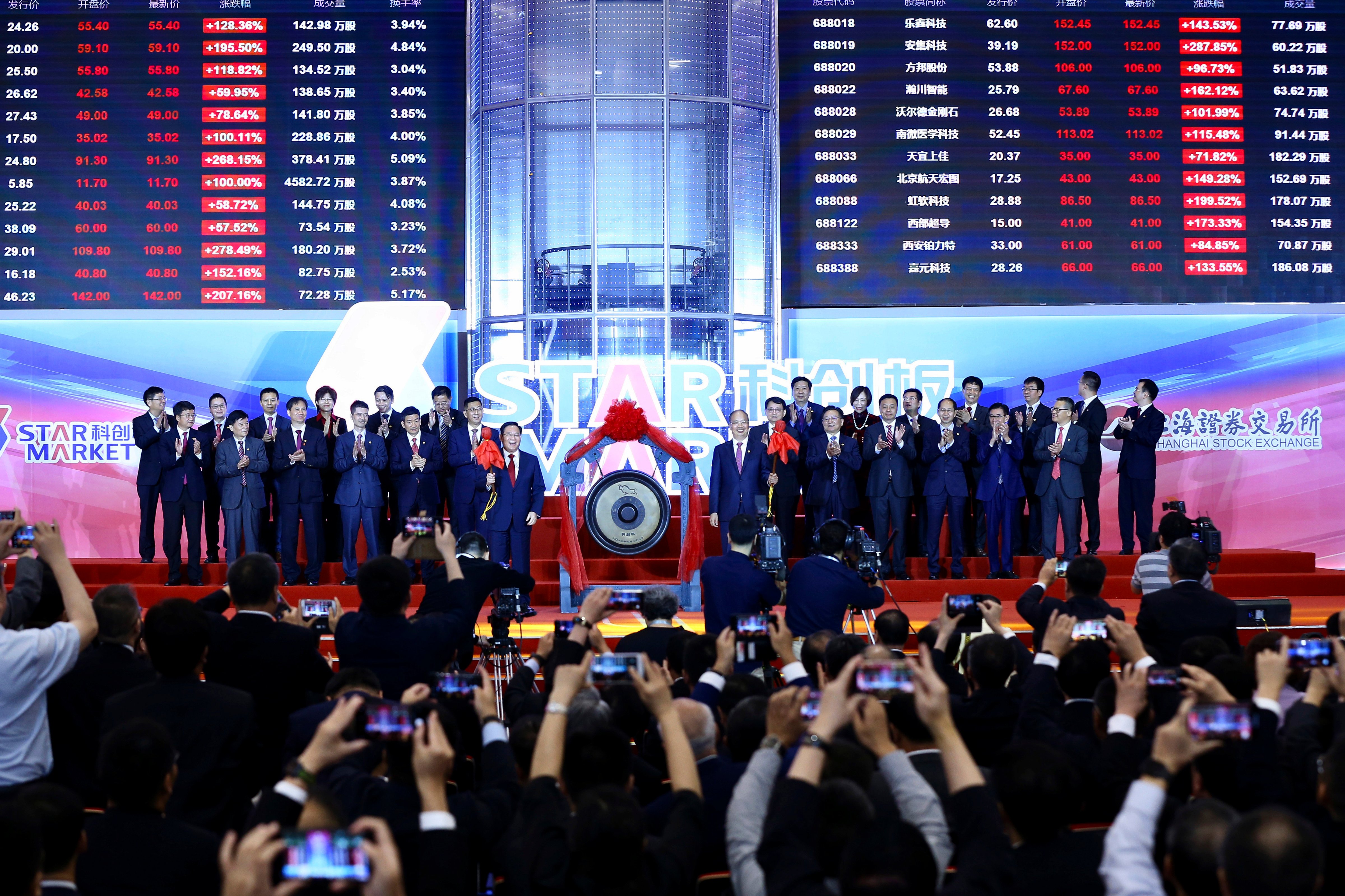 Li Qiang, center left, Shanghai's Party chief, and Yi Huiman, center right, chairman at China Securities Regulatory Commission, and the heads of 25 companies celebrate the launch of the SSE STAR Market in the hall of Shanghai Securities Exchange in Shanghai, China on July 22, 2019. (Chinatopix/AP)