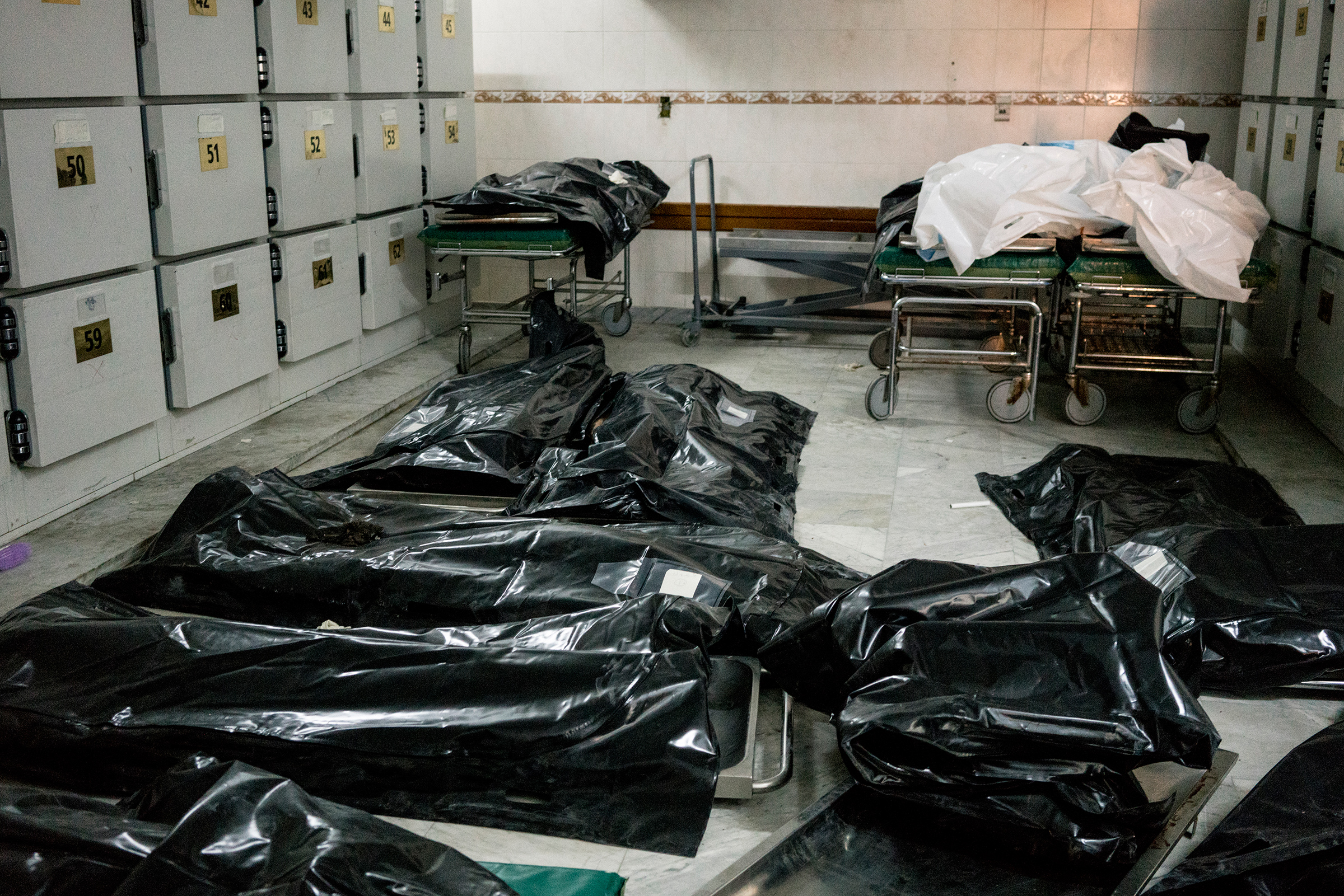 Bodies of migrants killed in the airstrike lay on the floor of the Tripoli Central Hospital morgue. (Emanuele Satolli)