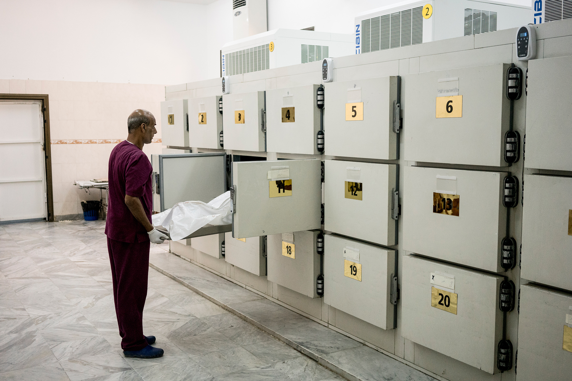 A body of a migrant killed in the airstrike is removed from a locker at the hospital morgue. (Emanuele Satolli)