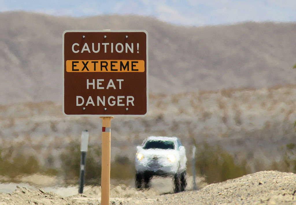 Heat waves rise near a heat danger warning sign on the eve in Death Valley National Park in California. (David McNew—Getty Images)