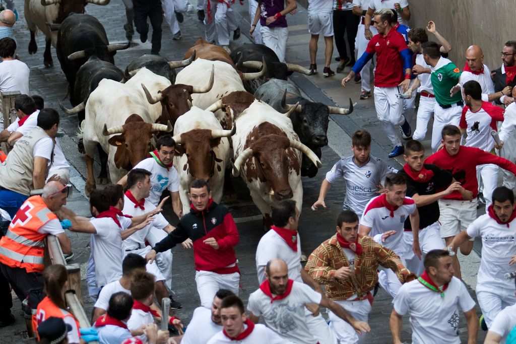 Participants run next to Miura fighting bulls on the last bullrun of the San Fermin festival in Pamplona, northern Spain, on July 12, 2019. (Jaime Reina – AFP/Getty Images)