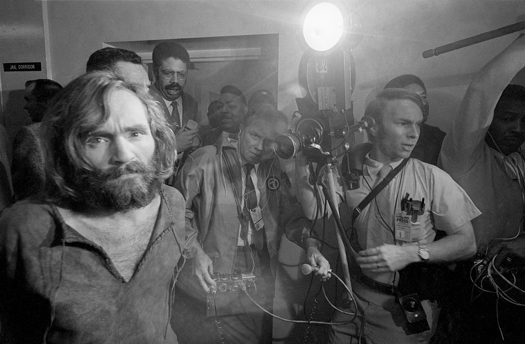 Cameramen film the scene as Charles Manson is brought into the Los Angeles city jail under suspicion of having masterminded the Tate-LaBianca murders of August 1969. (Bettmann—Bettmann Archive/Getty Images)