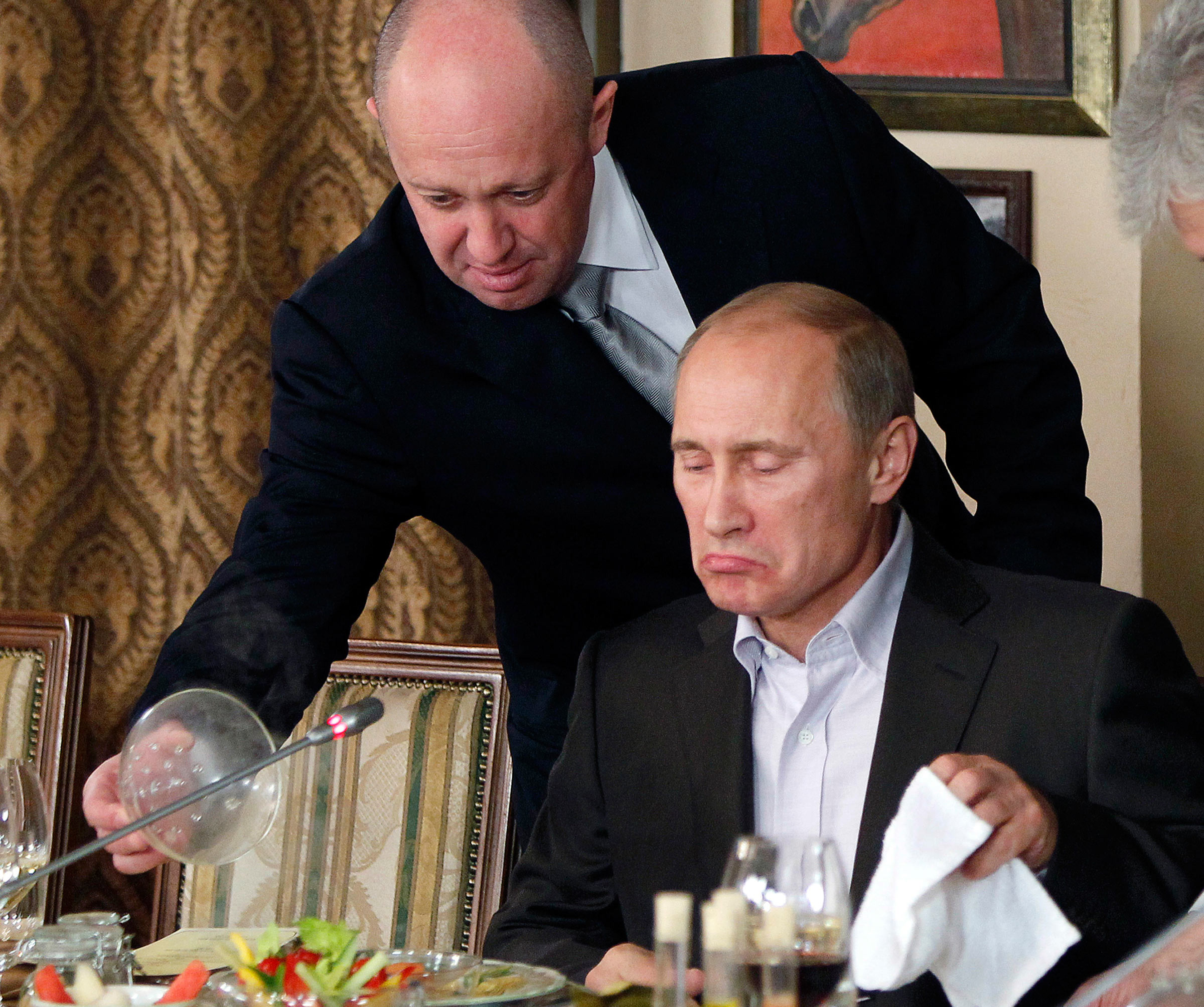 In this Nov. 11, 2011, file photo, Yevgeny Prigozhin, left, serves food to then-Russian Prime Minister Vladimir Putin at Prigozhin's restaurant outside Moscow, Russia. (Misha Japaridze—AP)