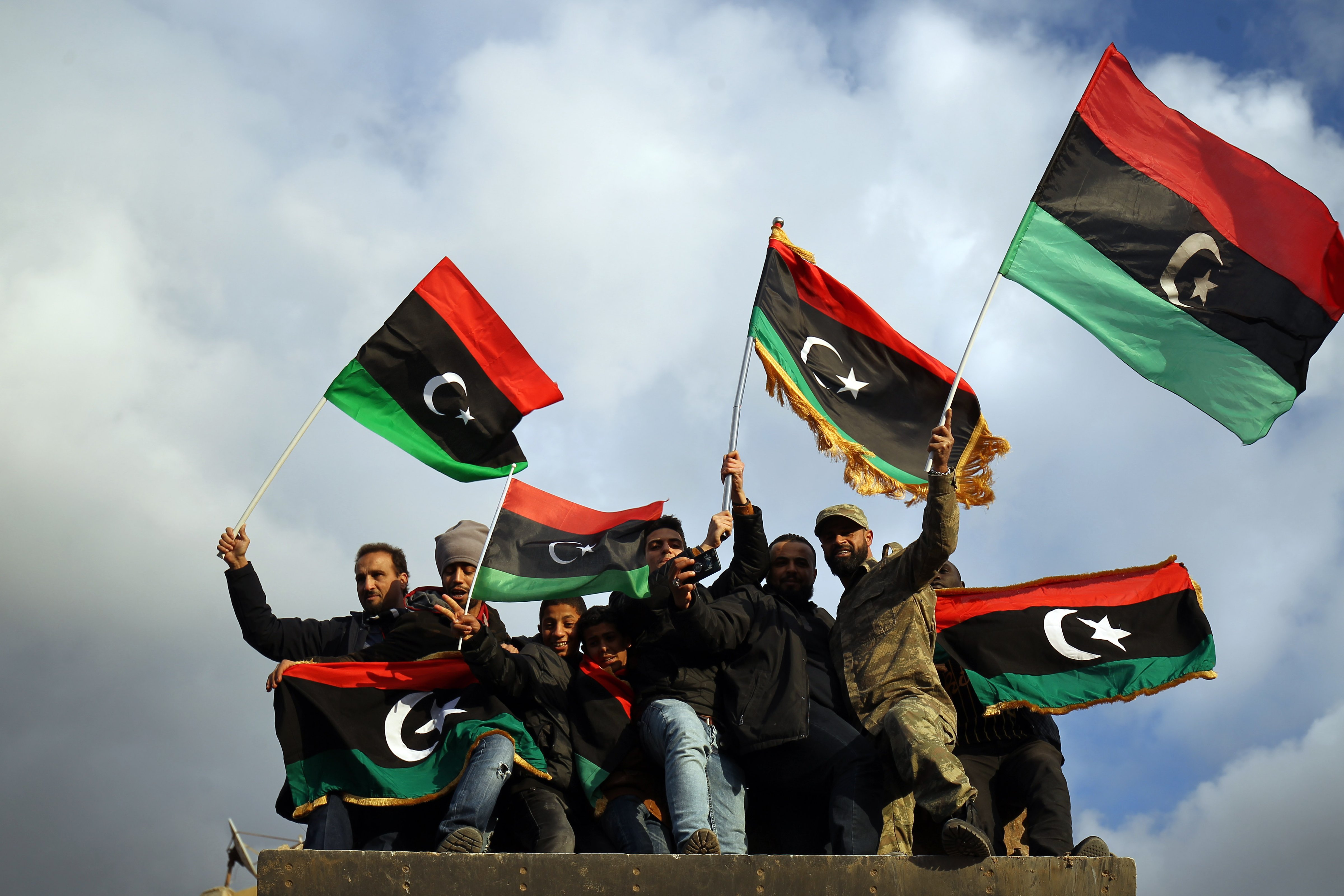 Libyans wave the national flag as they gather to mark the eighth anniversary of the uprising in Libya's second city of Benghazi, on February 17, 2019. (ABDULLAH DOMA—AFP/Getty Images)