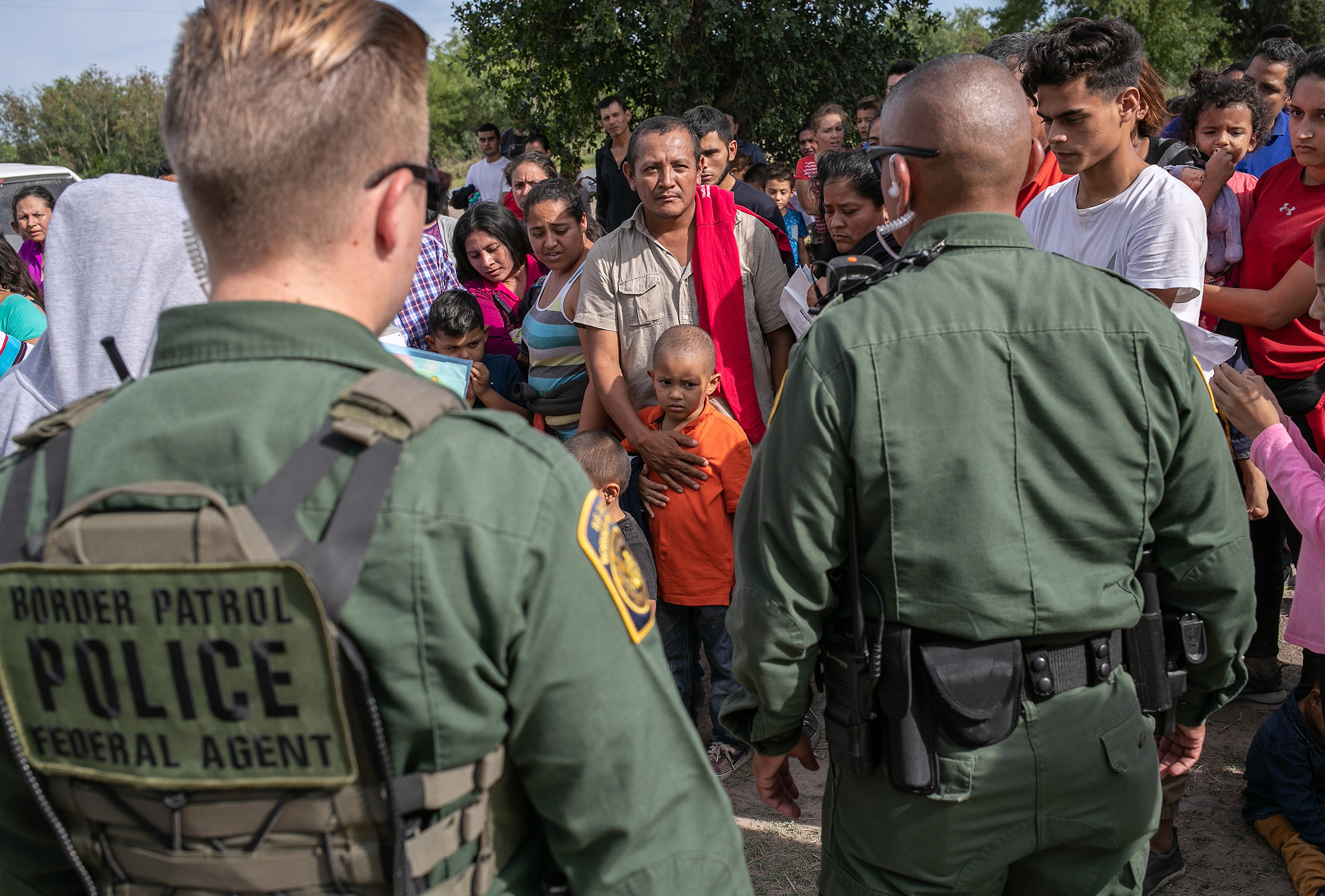 U.S. Border Patrol agents watch over immigrants after taking them into custody on July 02, 2019 in Los Ebanos, Texas.