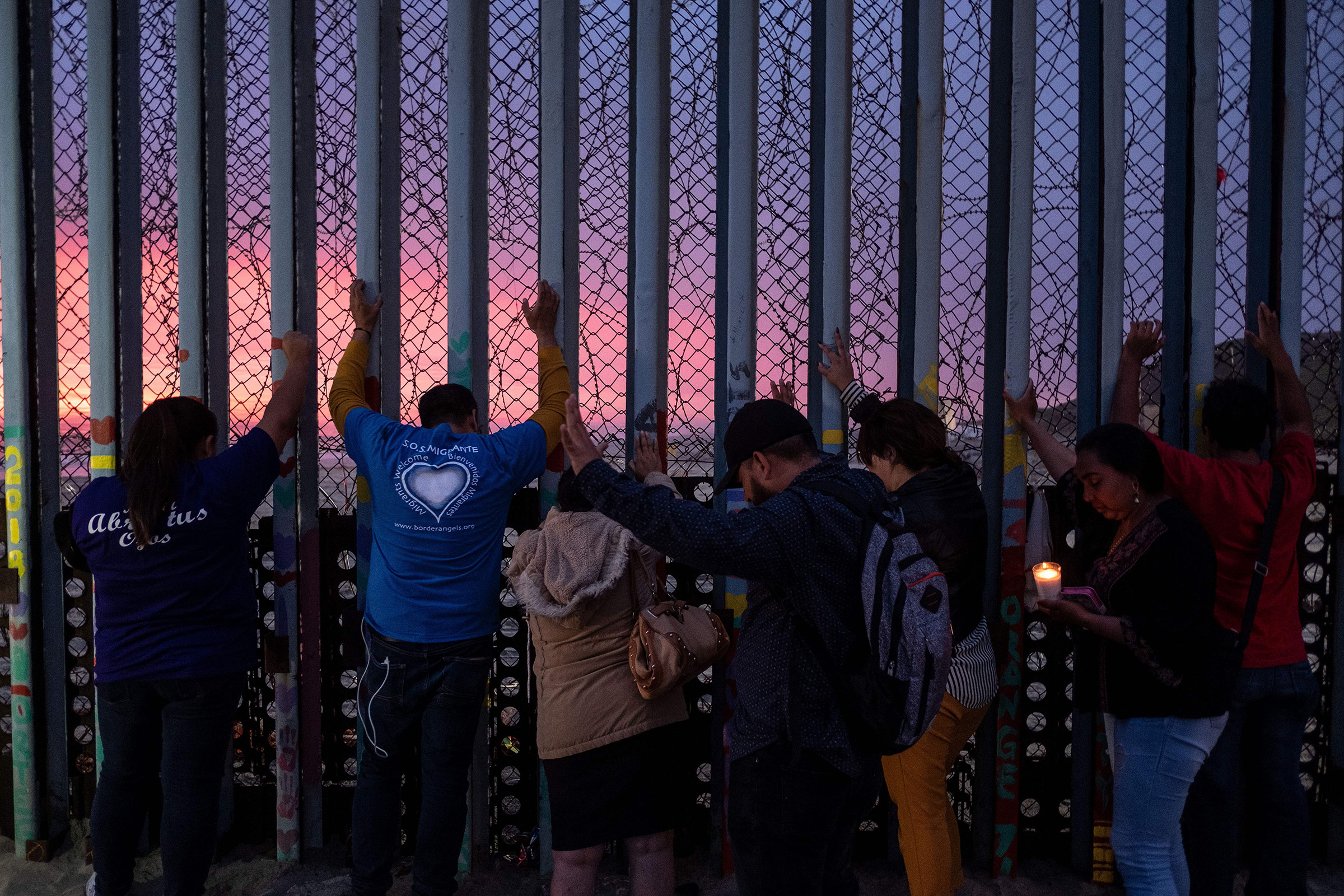 Migrants, advocates and attendees take part in an event called "Clamor for those who didn't achieve the dream" at the U.S.-Mexico border in Playas de Tijuana, Baja California state, Mexico, on June 29, 2019. (Guillermo Arias—AFP/Getty Images)
