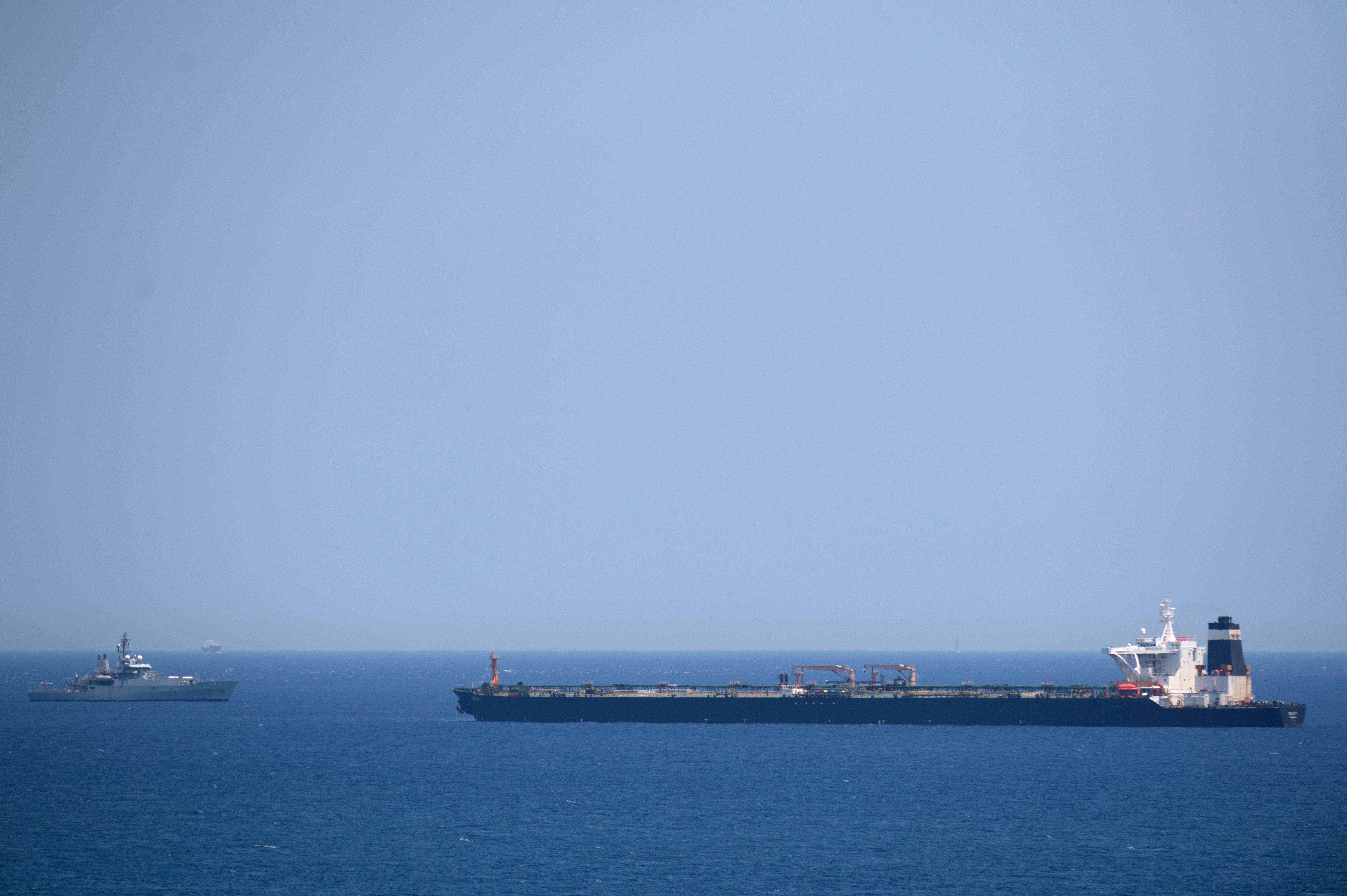 A British Royal Navy ship (L) patrols near supertanker Grace 1 suspected of carrying crude oil to Syria in violation of EU sanctions after it was detained off the coast of Gibraltar on July 4, 2019. (JORGE GUERRERO&mdash;AFP/Getty Images)