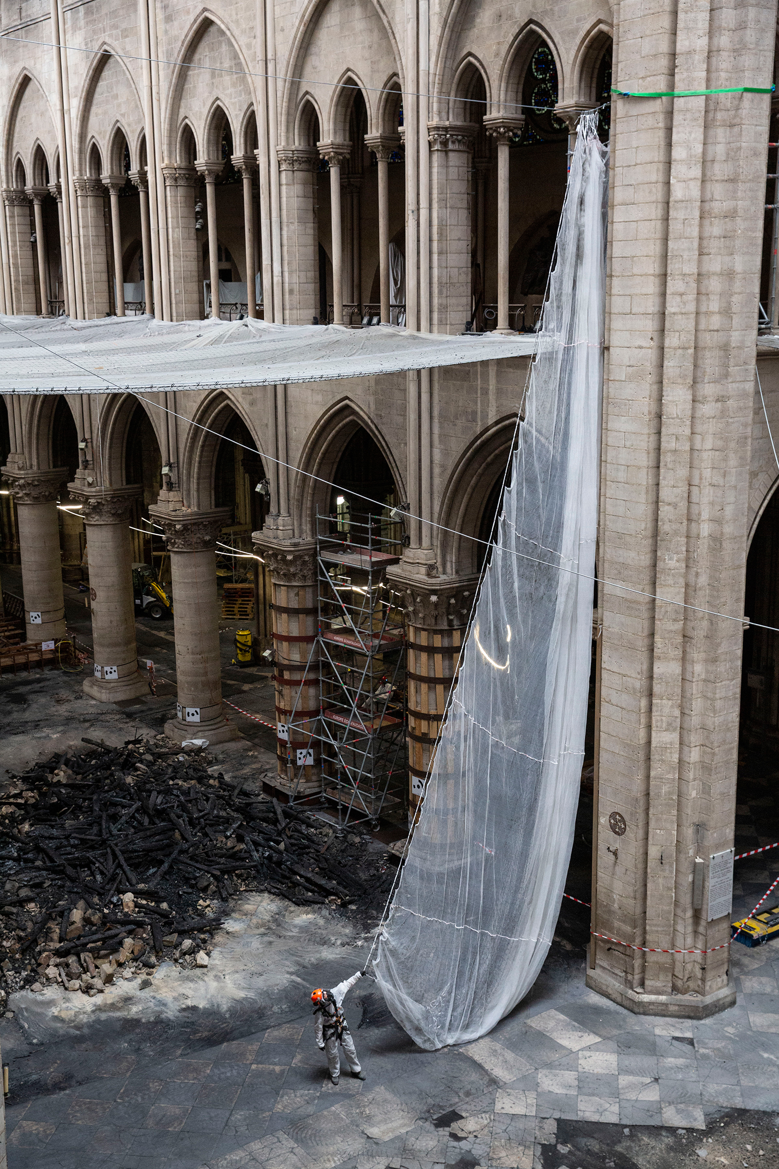 A worker prepares to install a net in the cathedral on July 11.