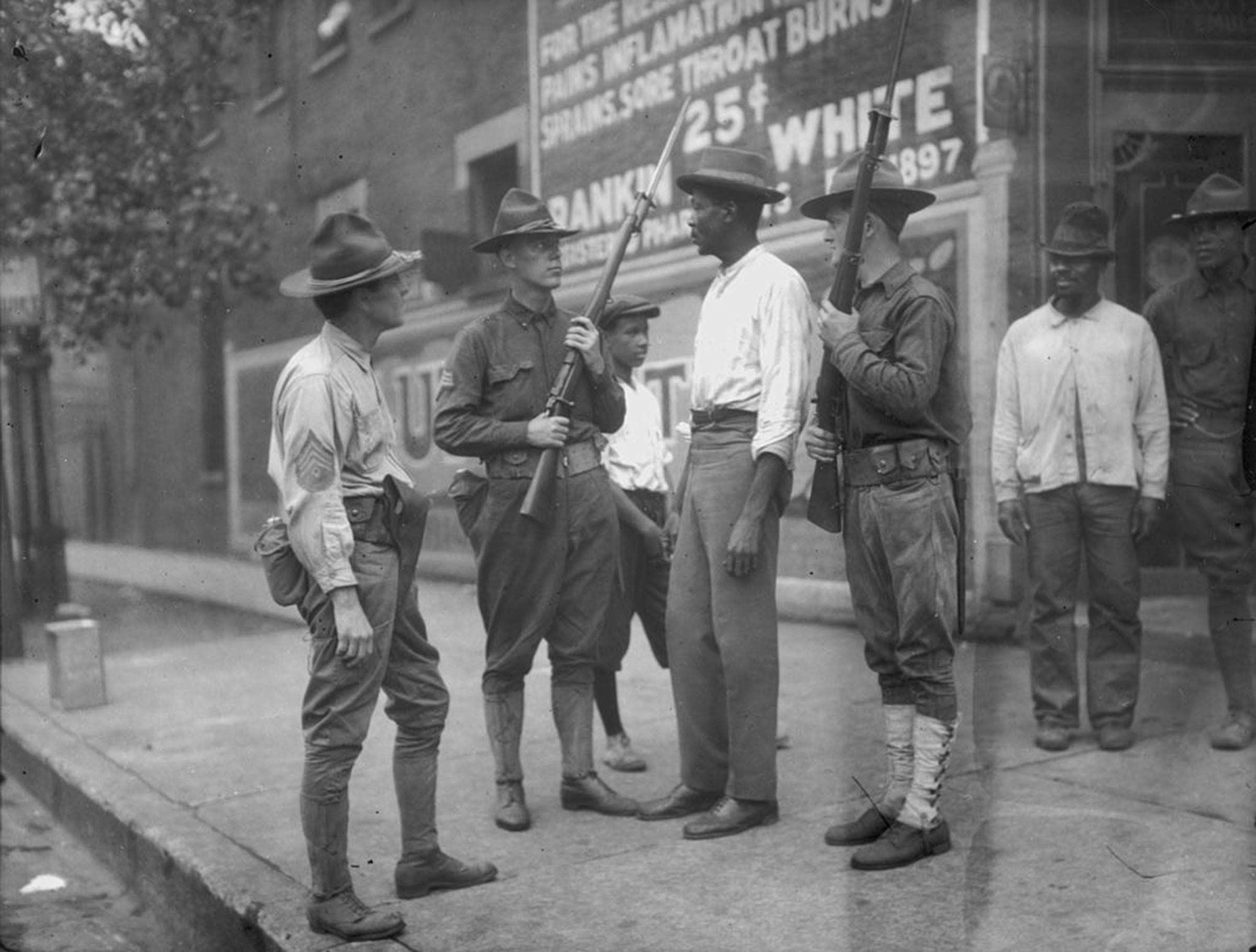 National Guardsmen question an African-American man in Chicago, after Mayor 'Big Bill' Thompson called in the National Guard on July 30, 1919, after three days of rioting. (Jun Fujita/Chicago History Museum—Getty Images)