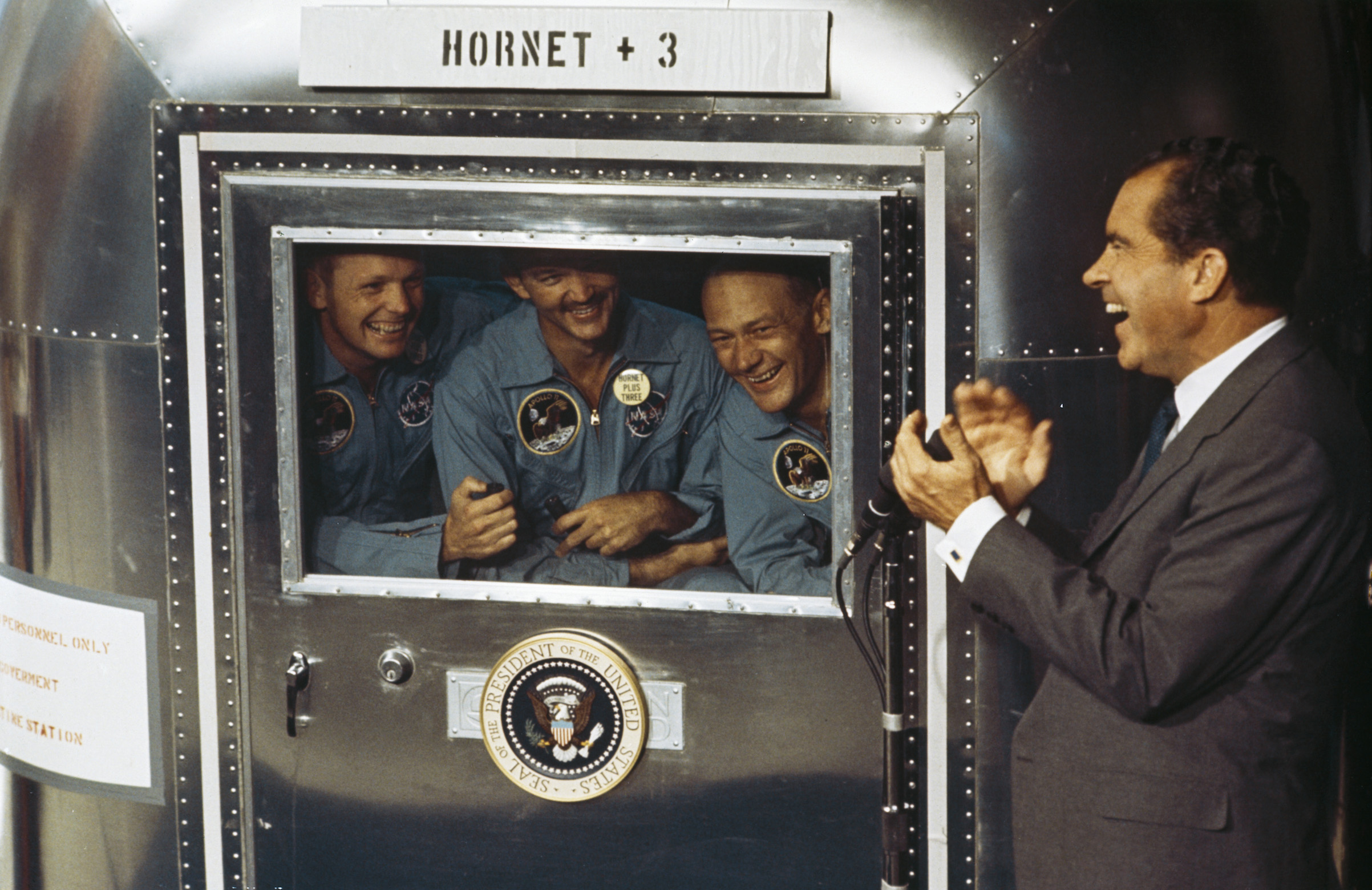 From left to right, Neil Armstrong, Michael Collins and Buzz Aldrin, the crew of the historic Apollo 11 moon landing mission, are subjected to a period of quarantine upon their return to earth. Through the window of their Mobile Quarantine Facility, they hold a conversation with President Richard Nixon. (MPI/Getty Images)
