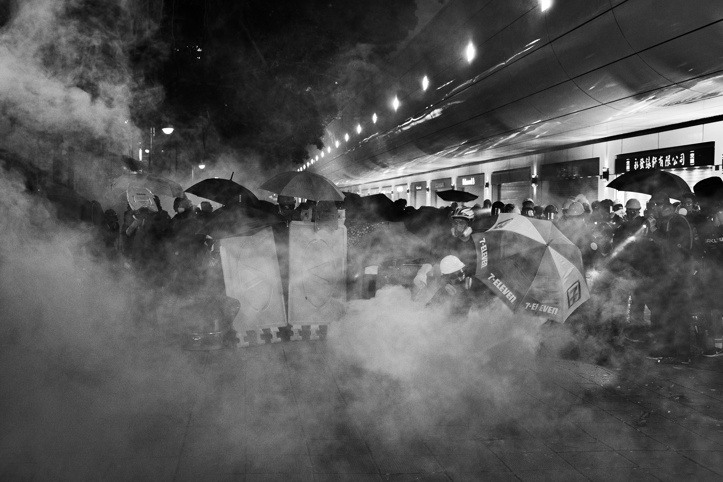 Protesters are tear-gassed by riot police near the Tsim Sha Tsui police station in Kowloon, Hong Kong, on Aug. 11. (Adam Ferguson for TIME)