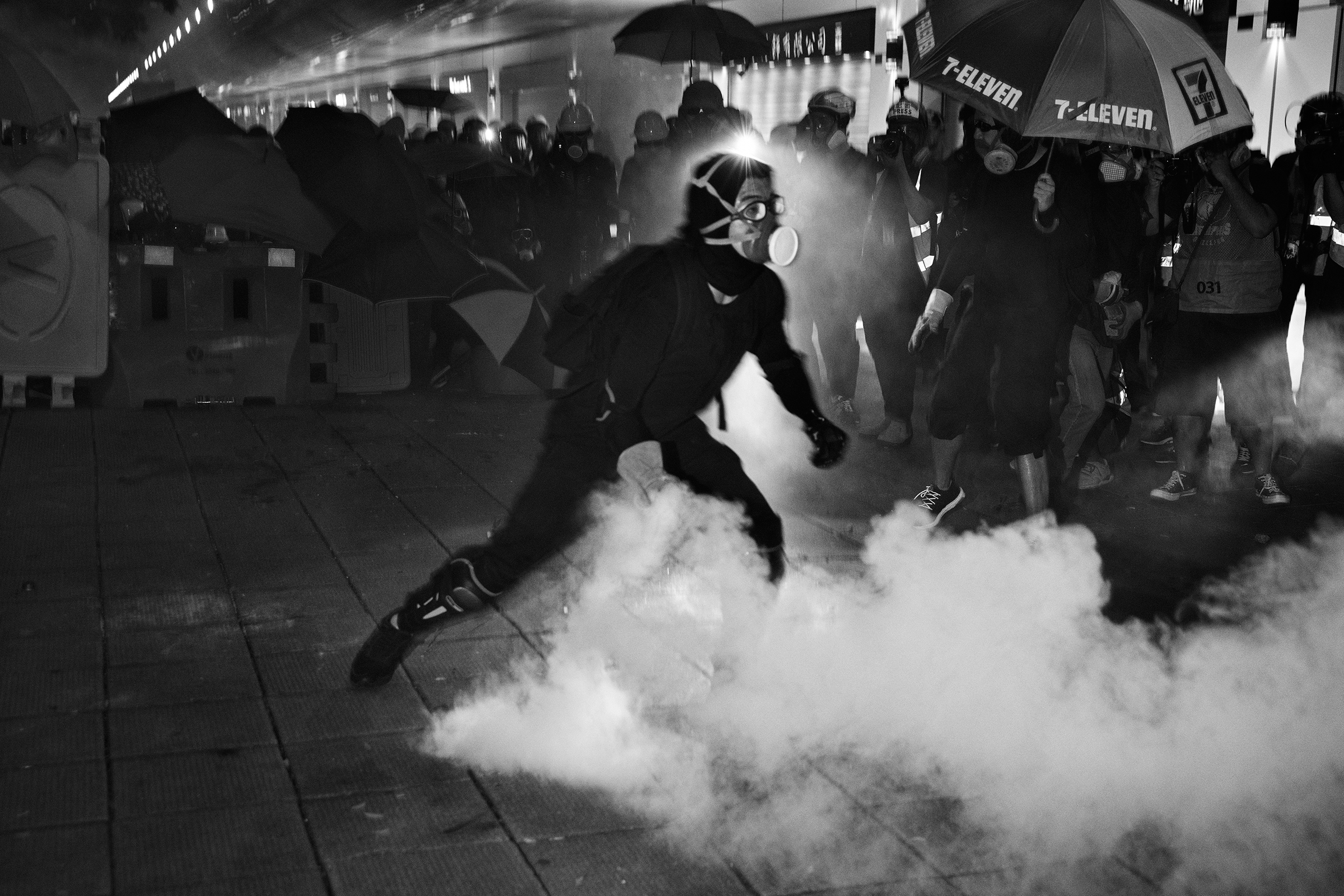 A protester throws a live tear-gas canister back at riot police during a protest near Tsim Sha Tsui police station in Kowloon, Hong Kong, on Aug. 11.