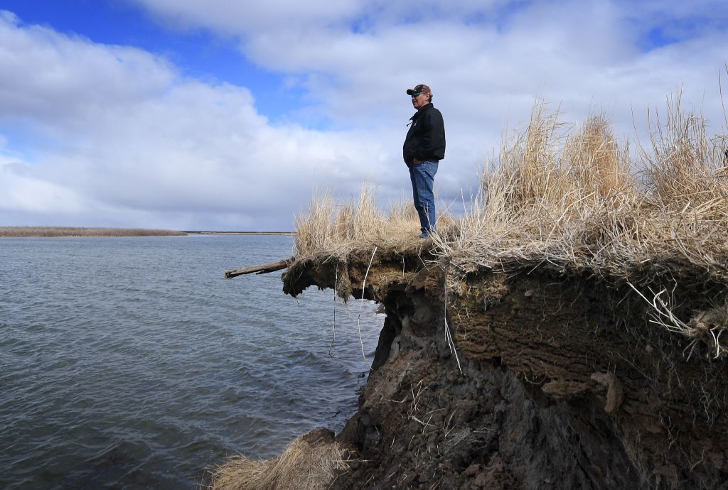 Tribal elder Warren Jones stands on a site threatened by climate change erosion caused by melting permafrost tundra and the disappearance of sea ice which formed a protective barrier, at the Yupik Eskimo village of Quinhagak on the Yukon Delta in Alaska on April 13, 2019. (MARK RALSTON&mdash;AFP/Getty Images)