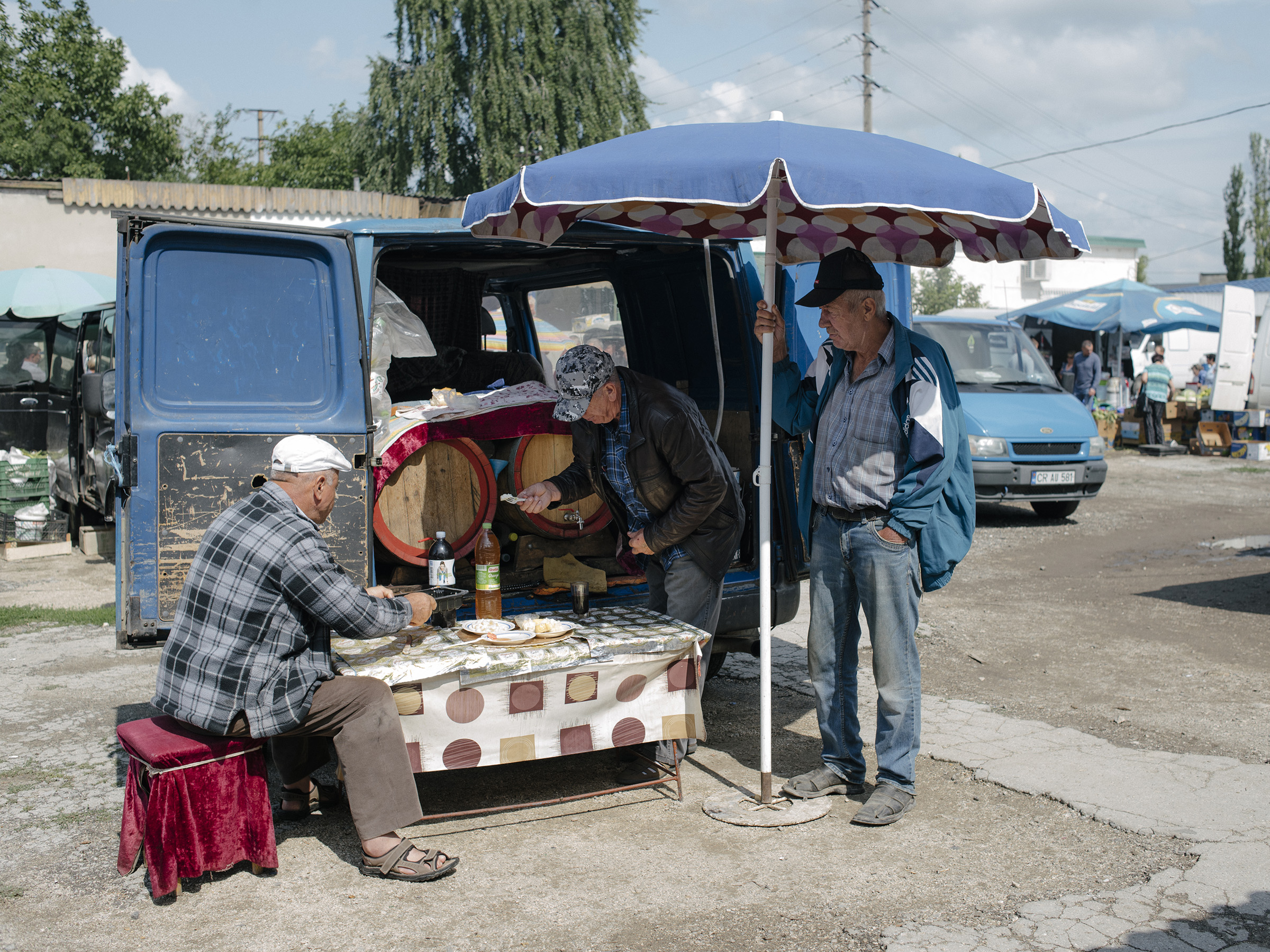 Gheorghe sells homemade wine at the Sunday markey in Straseni, Moldova, on Aug. 2, 2019. (Ramin Mazur for TIME)
