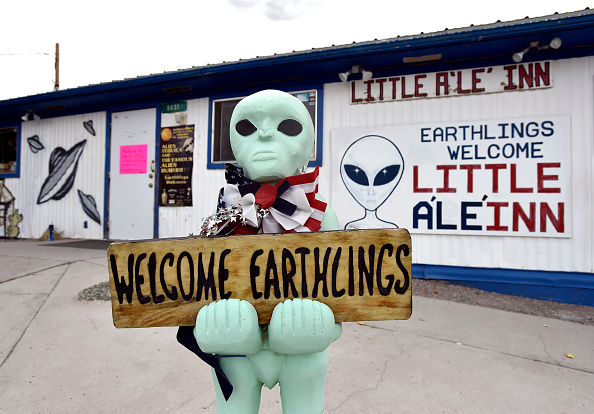 An alien-like statue displays a sign welcoming guests to the Little A'le'Inn restaurant and gift shop in Rachel, Nevada on July 22, 2019.