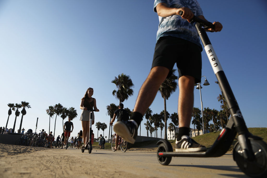 People ride Bird shared dockless electric scooters along Venice Beach on August 13, 2018 in Los Angeles, California. (Mario Tama—Getty Images)
