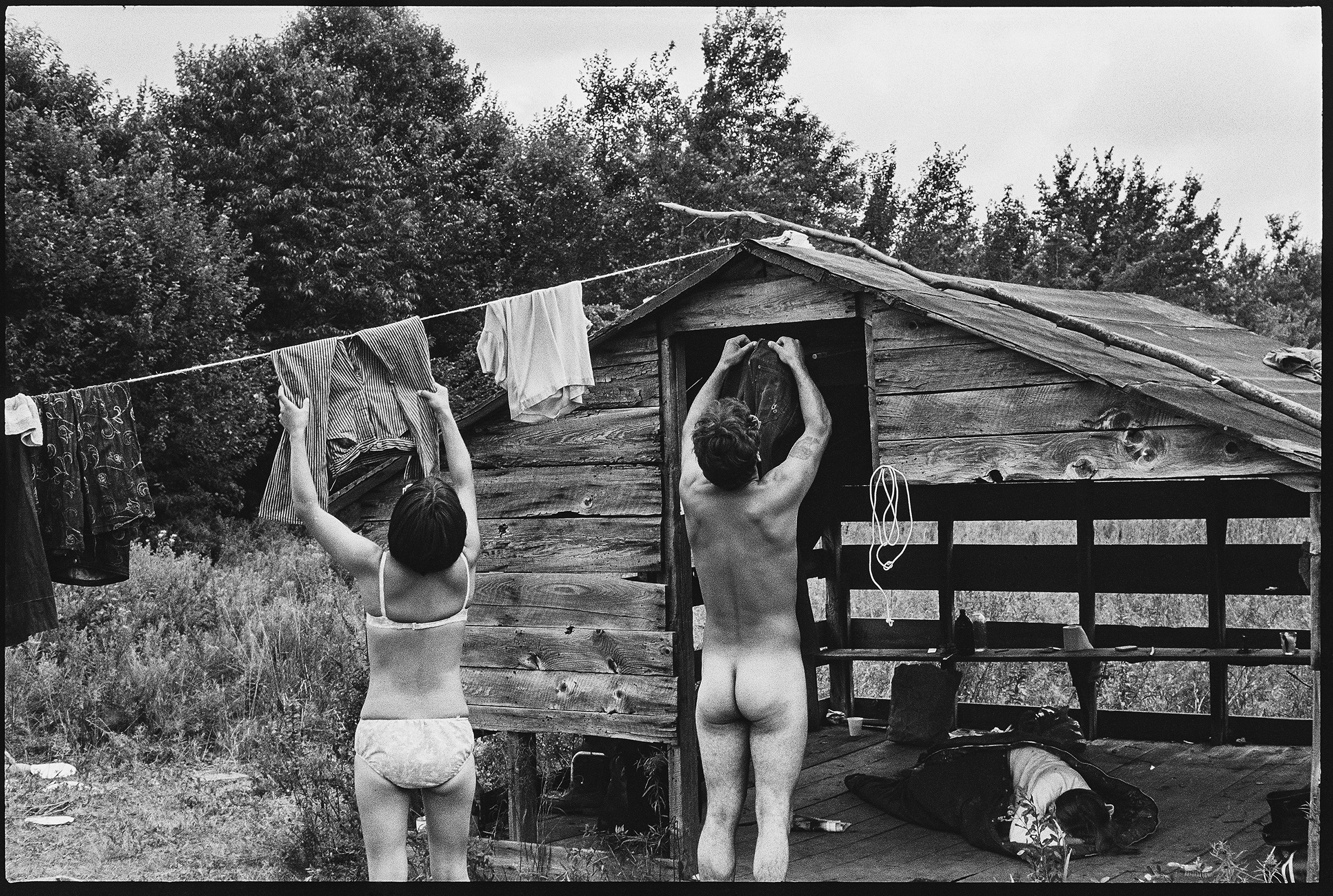 A couple hanging clothes out to dry on a hillside away from the crowd at Woodstock.