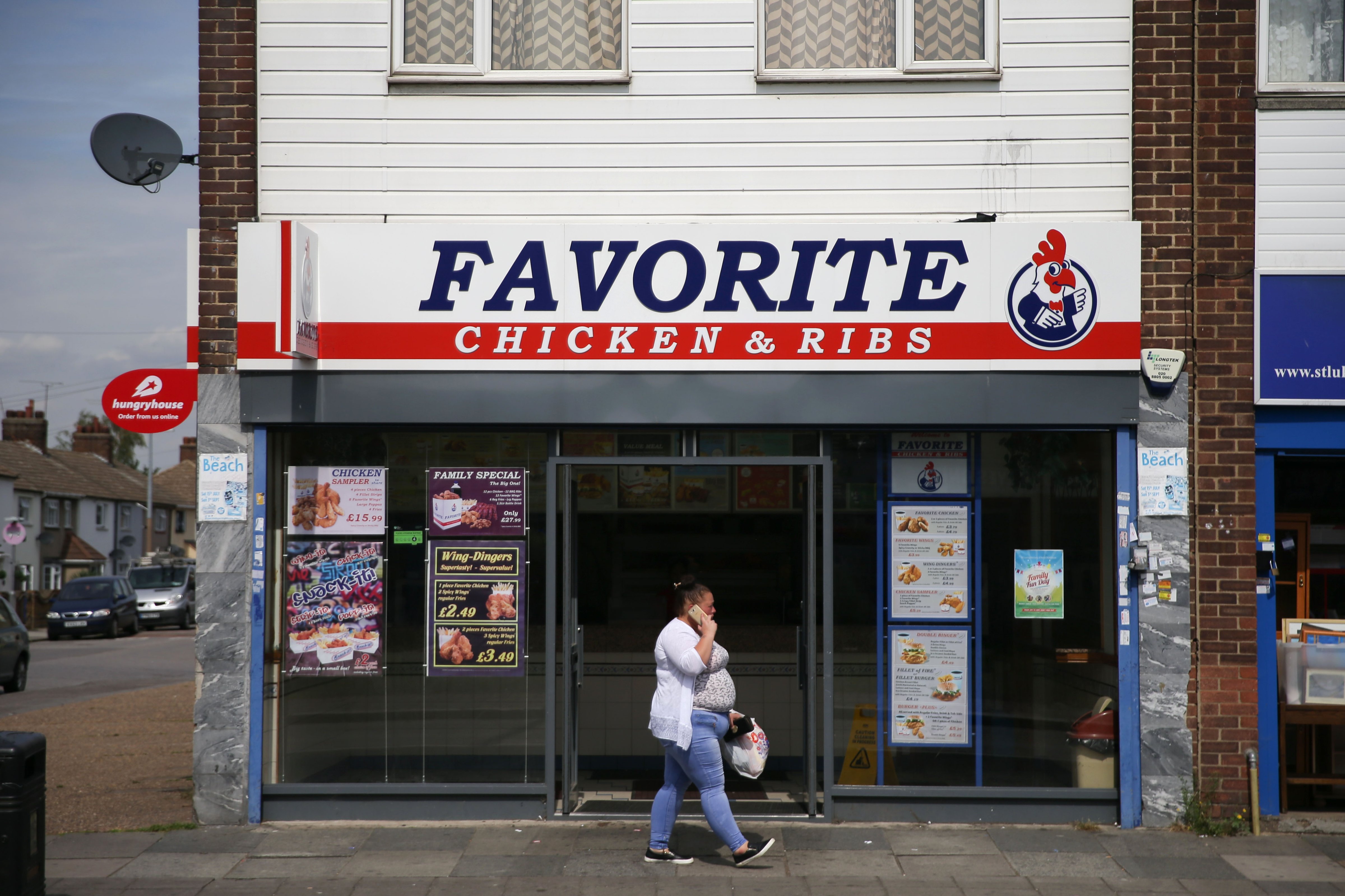 A resident walks past a fast food shop in the town of Tilbury in Essex, east of London on August 26, 2017. (DANIEL LEAL-OLIVAS—AFP/Getty Images)