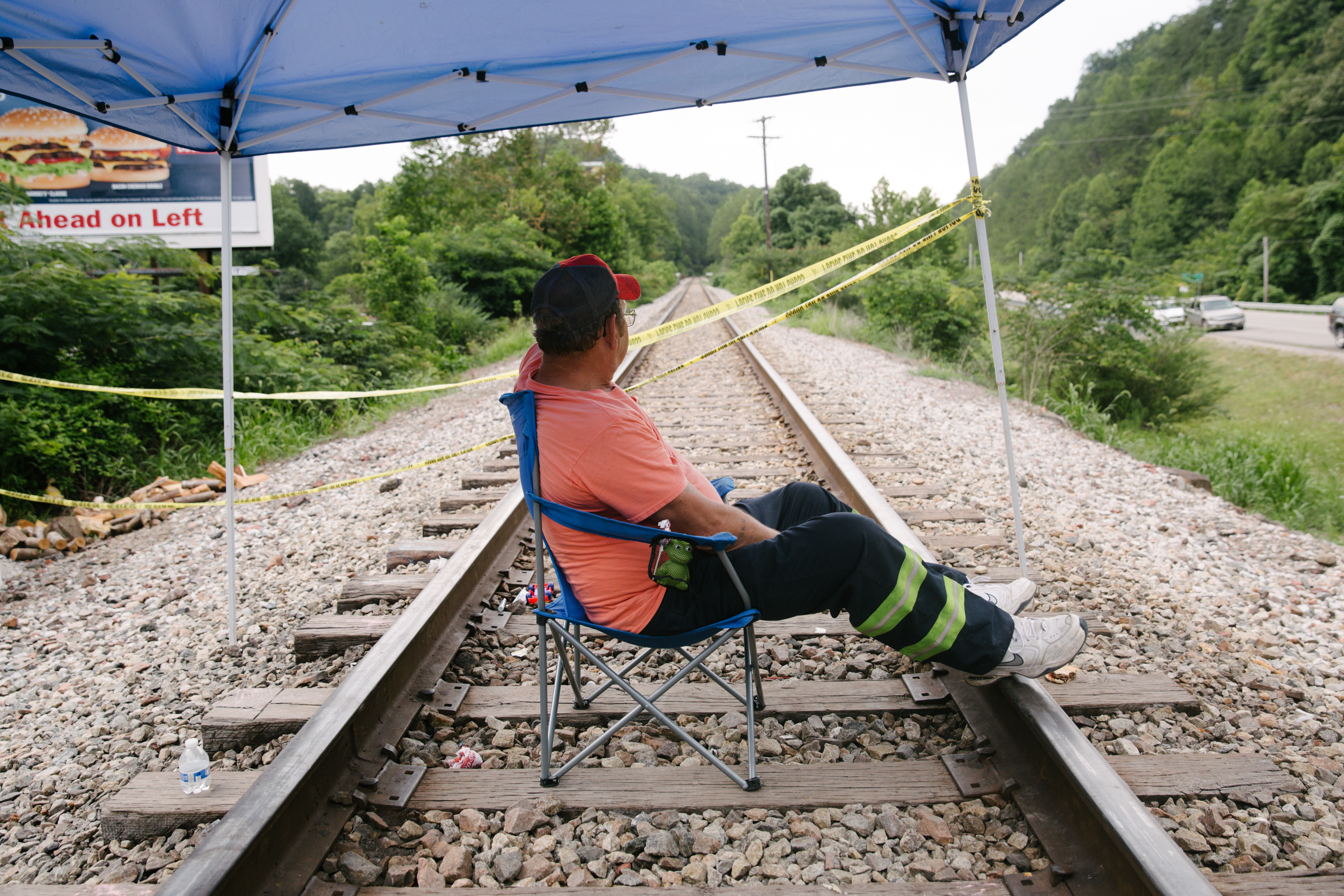 A miner sits on train tracks in Cumberland, Kentucky, U.S., on Friday, Aug. 2, 2019. The miners have been working in shifts to block railroad tracks leading to a Blackjewel mine outside since Monday afternoon, Harlan County Judge-Executive Dan Mosley said in an interview. (Meg Roussos/Bloomberg via Getty Images)