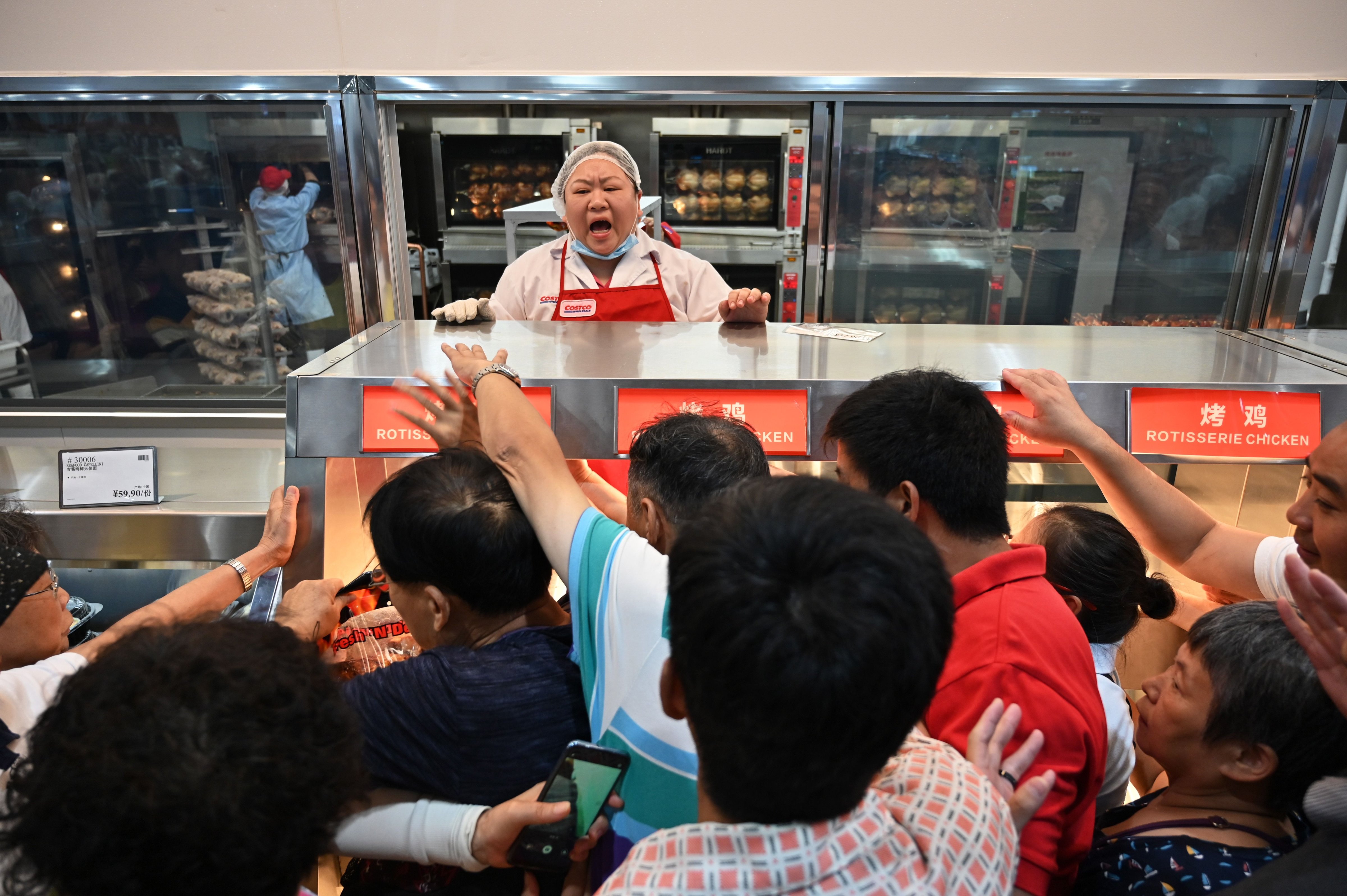 People try to get a roast chicken at the first Costco outlet in China, on the stores opening day in Shanghai on August 27, 2019. (HECTOR RETAMAL—AFP/Getty Images)
