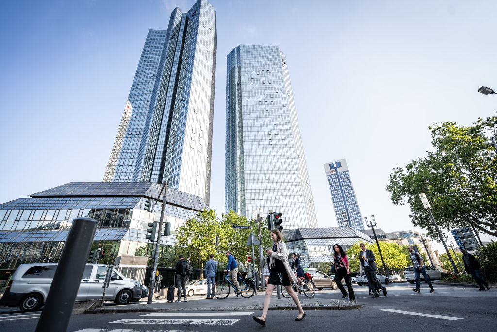 Pedestrians cross a road outside the Deutsche Bank AG headquarters during morning rush hour in the financial district of Frankfurt, Germany, on Wednesday, Aug, 21, 2019. (Peter Juelich—Bloomberg/Getty Images)