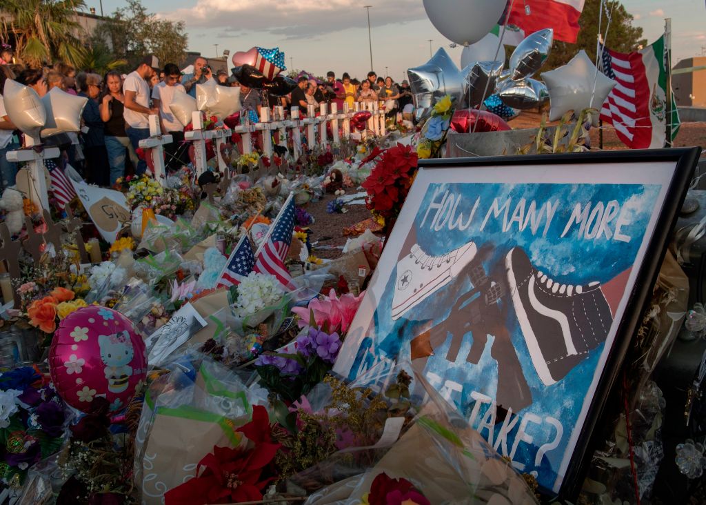 People pray and pay their respects at the makeshift memorial for victims of the shooting that left a total of 22 people dead at the Cielo Vista Mall WalMart (background) in El Paso, Texas, on August 6, 2019. (Mark Ralson—AFP/Getty Images)
