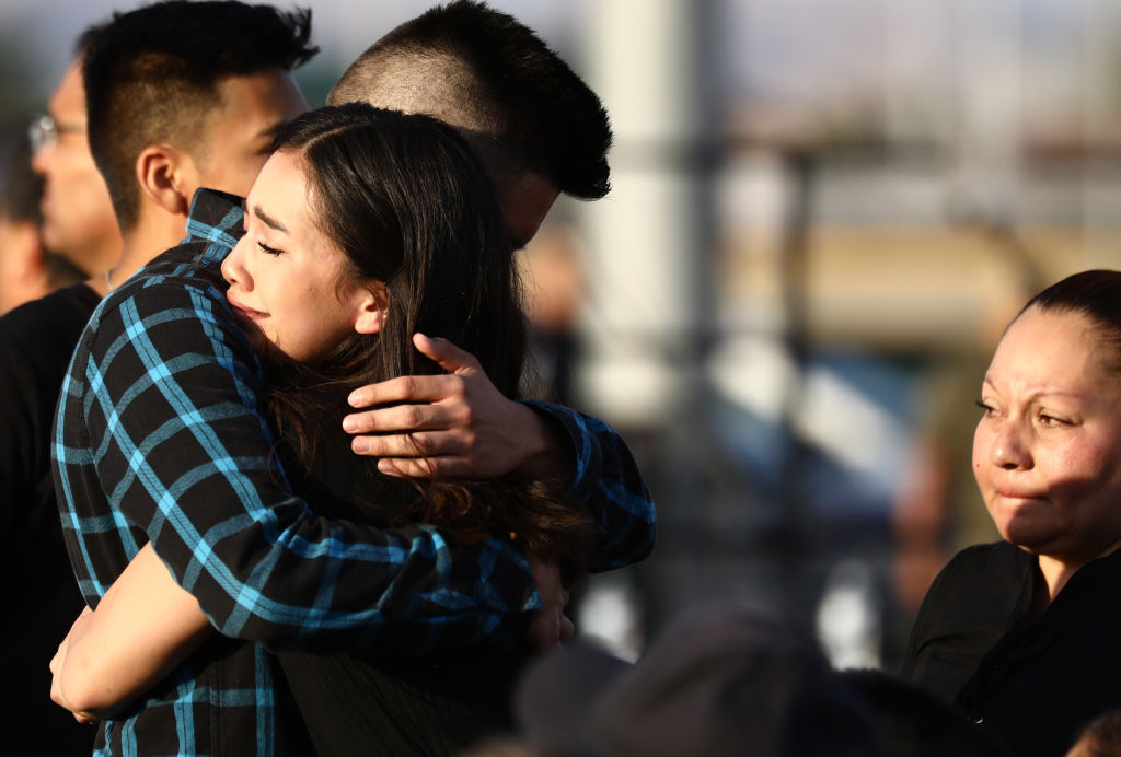 Mourners embrace at a vigil honoring Horizon High School sophomore Javier Amir Rodriguez, who lost his life in a mass shooting in nearby El Paso, on August 5, 2019 in Horizon City, Texas. The vigil was held at the school's football field. (Mario Tama—Getty Images)