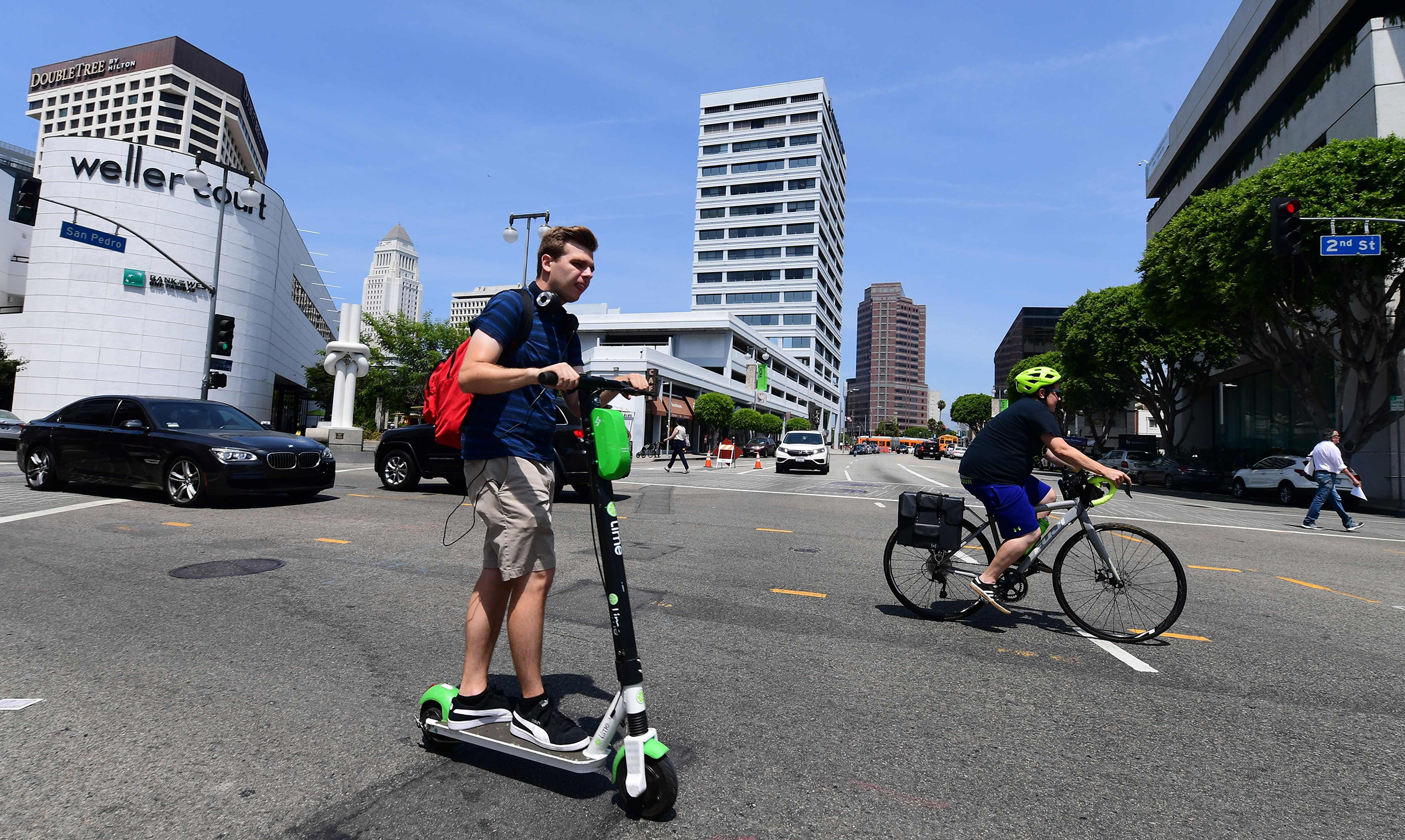 A commuter rides an e-scooter across a Los Angeles street on August 22, 2019, where an e-scooter enforcement task force has been launched in an effort to ensure riders follow the laws. (Frederic J. Brown—AFP/Getty Images)
