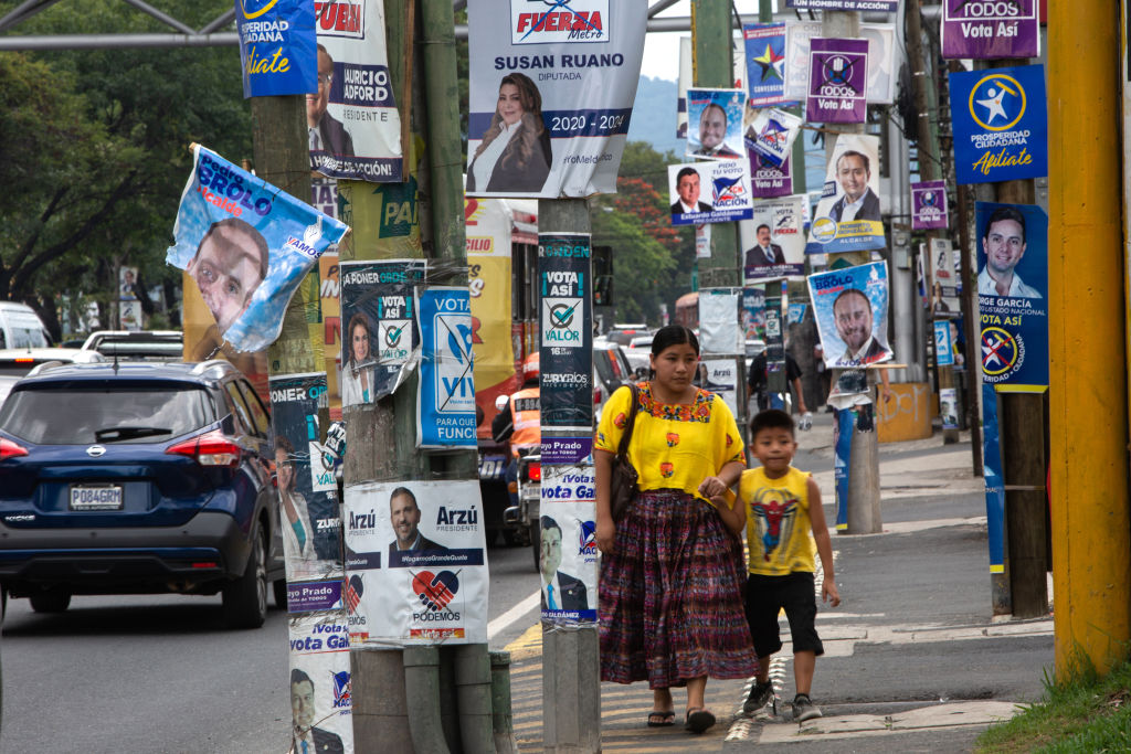 Pedestrians walk past campaign signs displayed during presidential elections in Guatemala City, Guatemala, on Sunday, June 16, 2019. (James Rodriguez—Bloomberg/Getty Images)