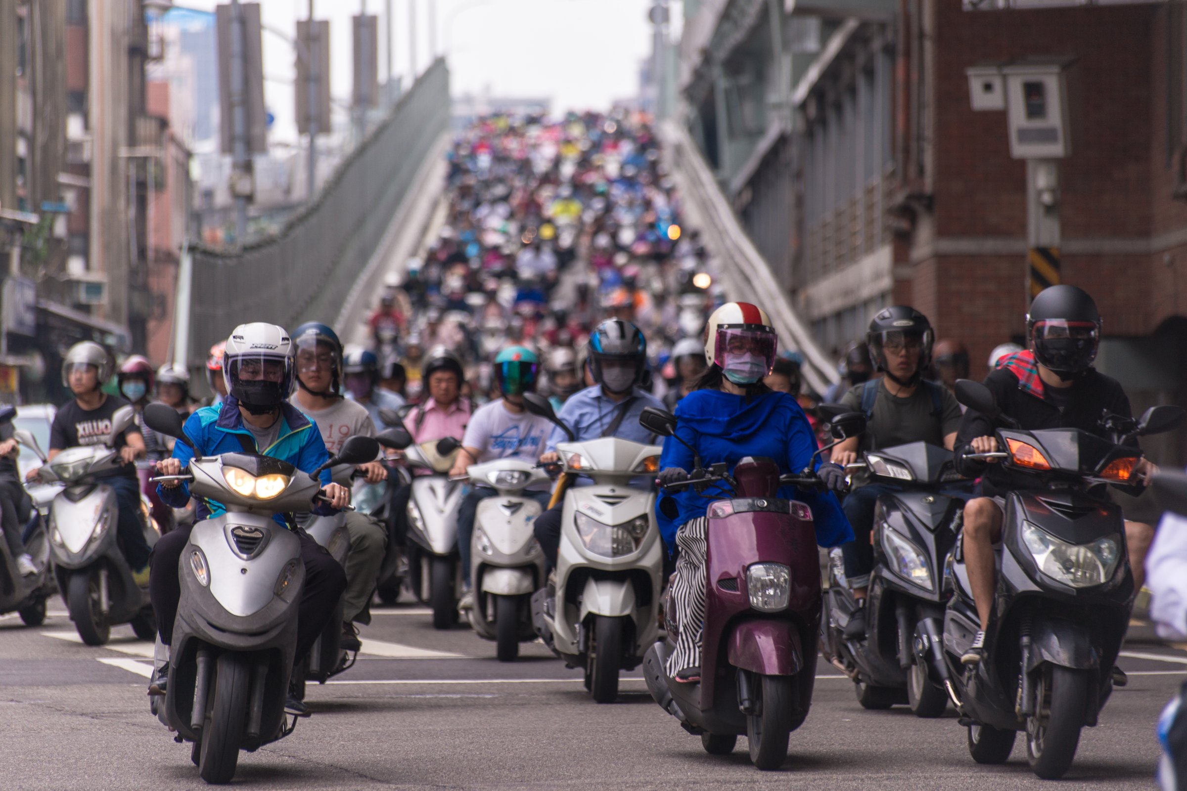 Taipei, Taiwan - June 13, 2018: Motorcycles go down the Taipei bridge during rush hour in the morning.﻿
