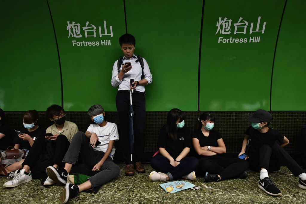 Protesters sit on a platform of a MTR underground train after some blocked the train doors at Fortress Hill station in Hong Kong on Aug. 5, 2019. (Anthony Wallace&mdash;AFP/Getty Images)