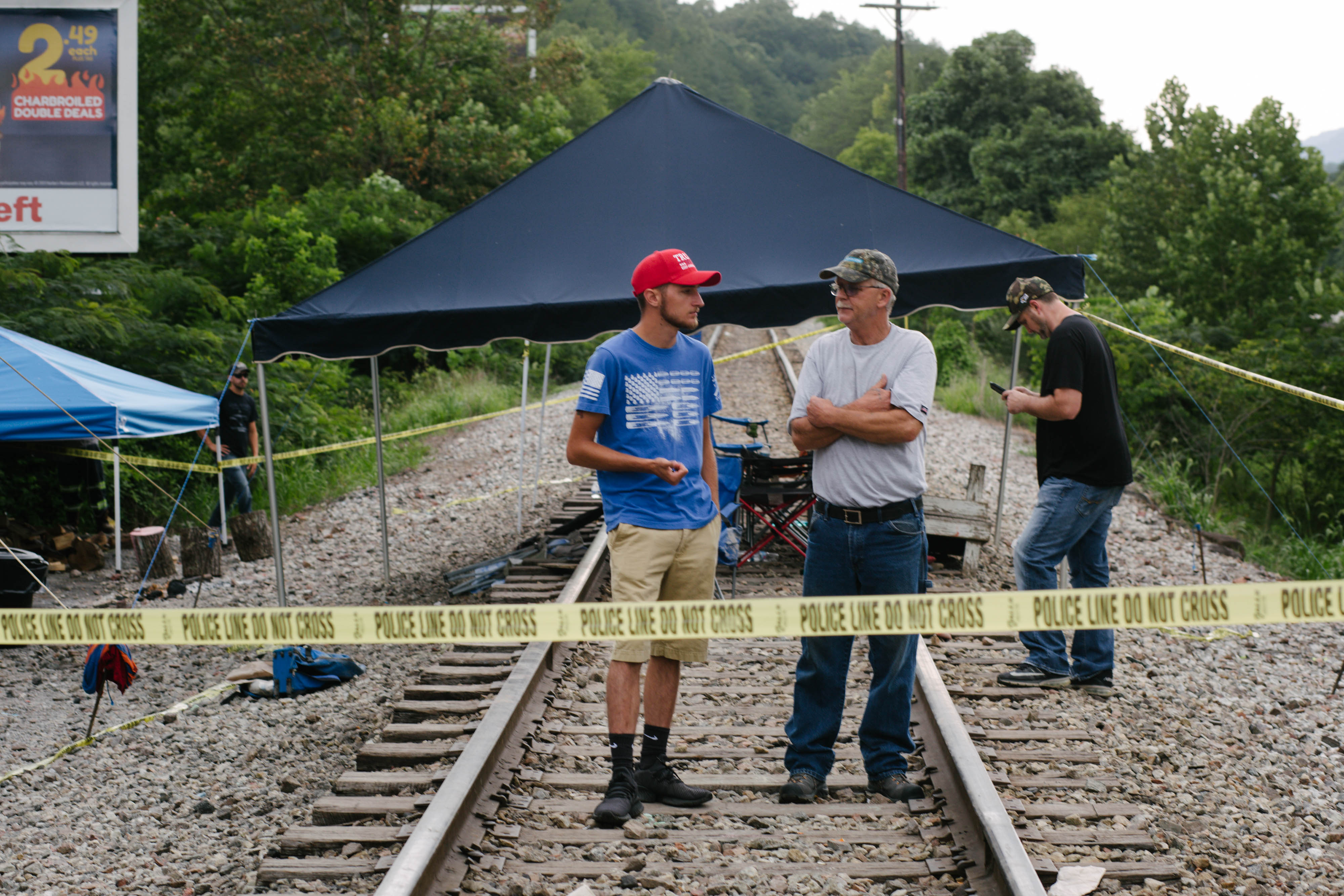 Miners stand on train tracks in Cumberland, Kentucky, U.S., on Friday, Aug. 2, 2019. The miners have been working in shifts to block railroad tracks leading to a Blackjewel mine outside since Monday afternoon, Harlan County Judge-Executive Dan Mosley said in an interview. They're demanding back pay for work done in weeks leading up to the bankruptcy, after checks issued by Blackjewel bounced or never arrived. Photographer: via Getty Images (Meg Roussos—Bloomberg/Getty Images)