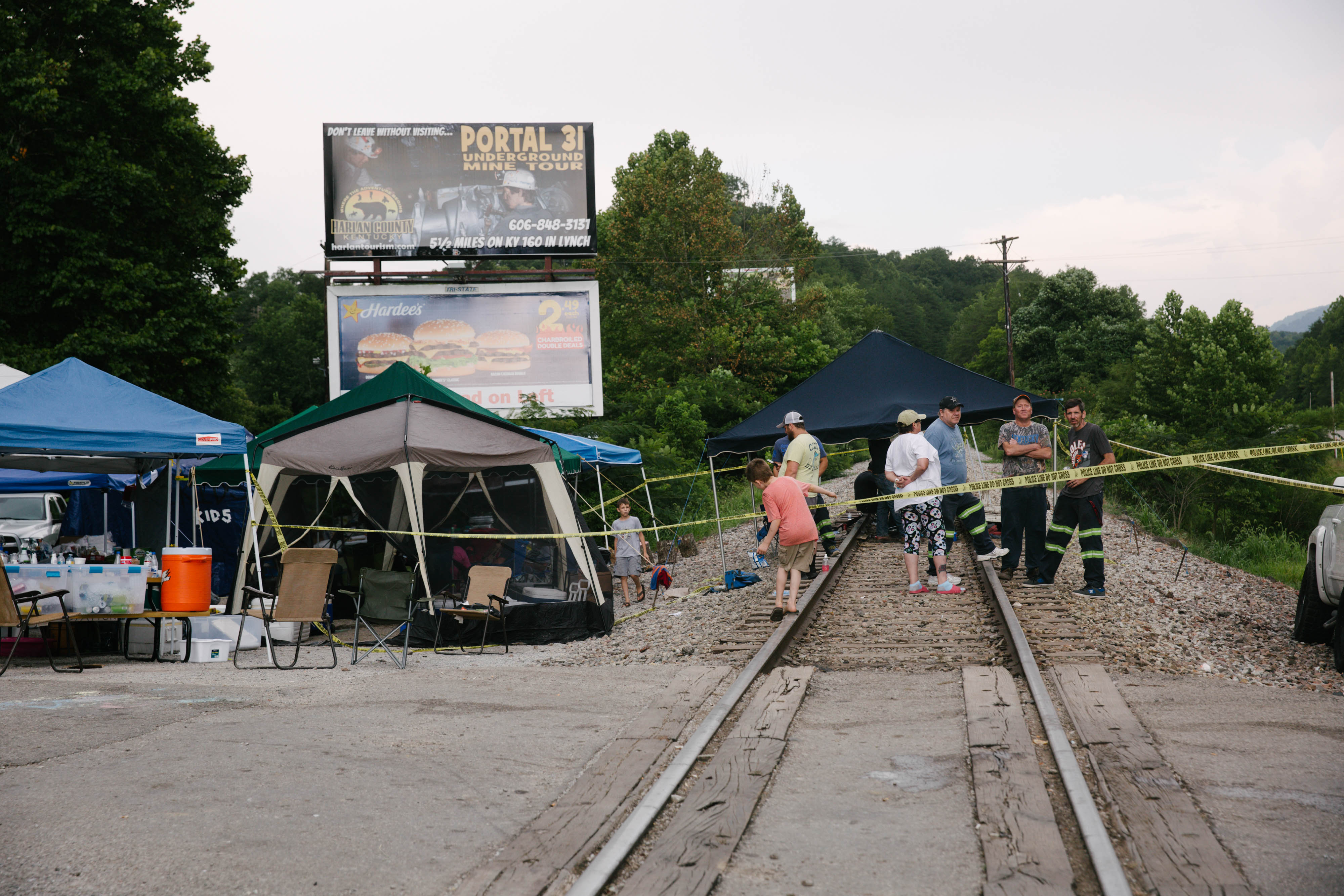 Supporters of miners stand on train tracks in Cumberland, Kentucky, U.S., on Friday, Aug. 2, 2019. The miners have been working in shifts to block railroad tracks leading to a Blackjewel mine outside since Monday afternoon, Harlan County Judge-Executive Dan Mosley said in an interview. (Meg Roussos/Bloomberg via Getty Images)
