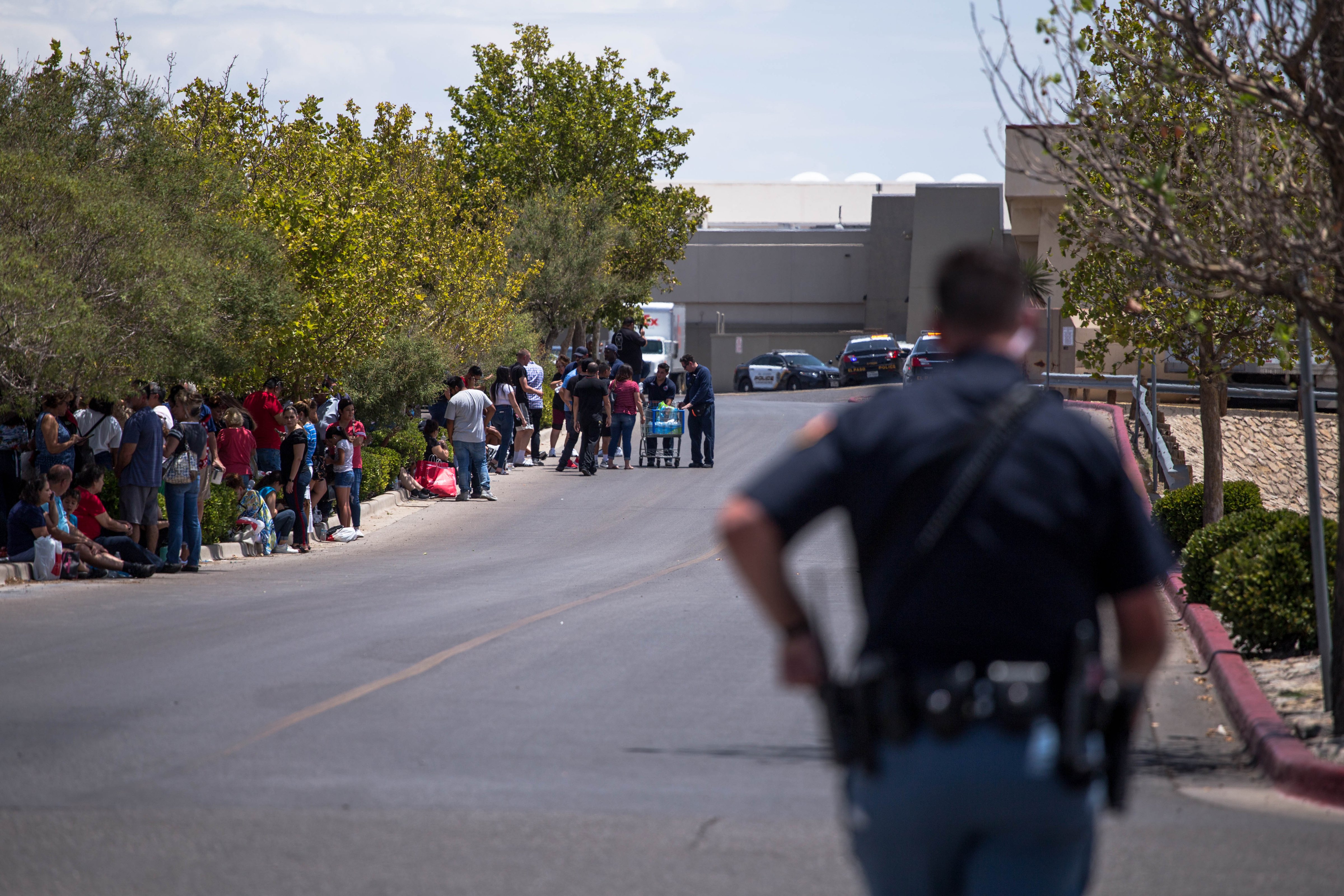 Individuals that were evacuated sit in a parking lot across from a Walmart where a shooting occurred at Cielo Vista Mall in El Paso, Texas, Saturday, Aug. 3, 2019. (JOEL ANGEL JUAREZ—AFP/Getty Images)