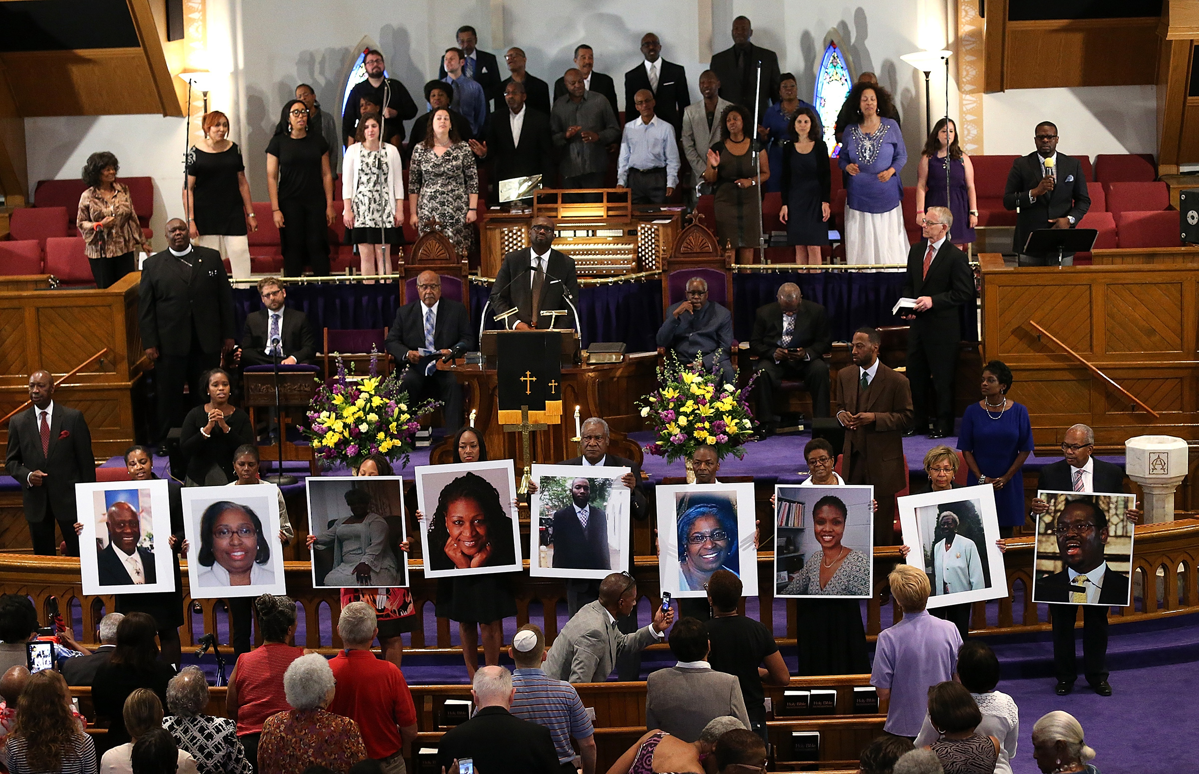 Photographs of the nine victims killed at the Emanuel African Methodist Episcopal Church in Charleston are held up by congregants during a prayer vigil at the the Metropolitan AME Church June 19, 2015 in Washington, DC. (Win McNamee—Getty Images)