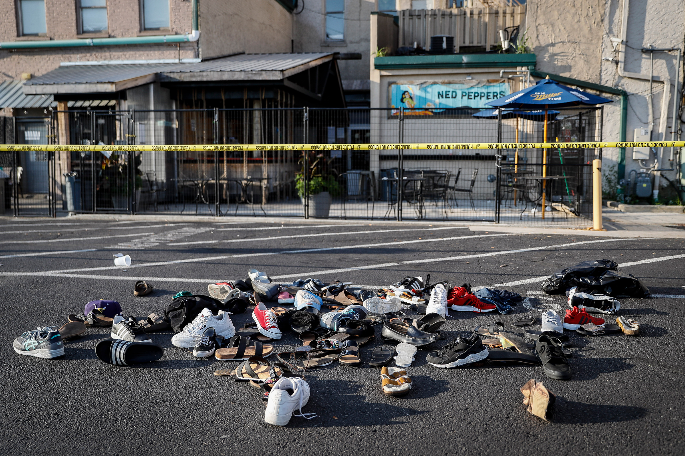 Shoes are piled outside the scene of a mass shooting including Ned Peppers bar, Sunday, Aug. 4, 2019, in Dayton, Ohio. Several people in Ohio have been killed in the second mass shooting in the U.S. in less than 24 hours, and the suspected shooter is also deceased, police said. (John Minchillo—AP)