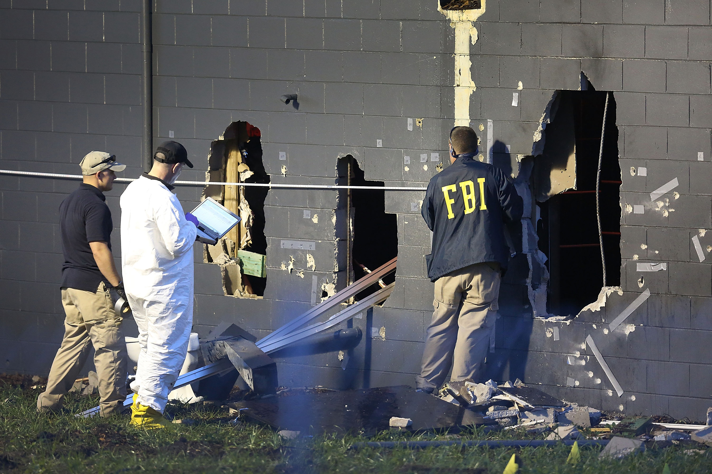 FBI agents investigate near the damaged rear wall of the Pulse Nightclub where Omar Mateen allegedly killed at least 50 people on June 12, 2016 in Orlando. (Joe Raedle—Getty Images)