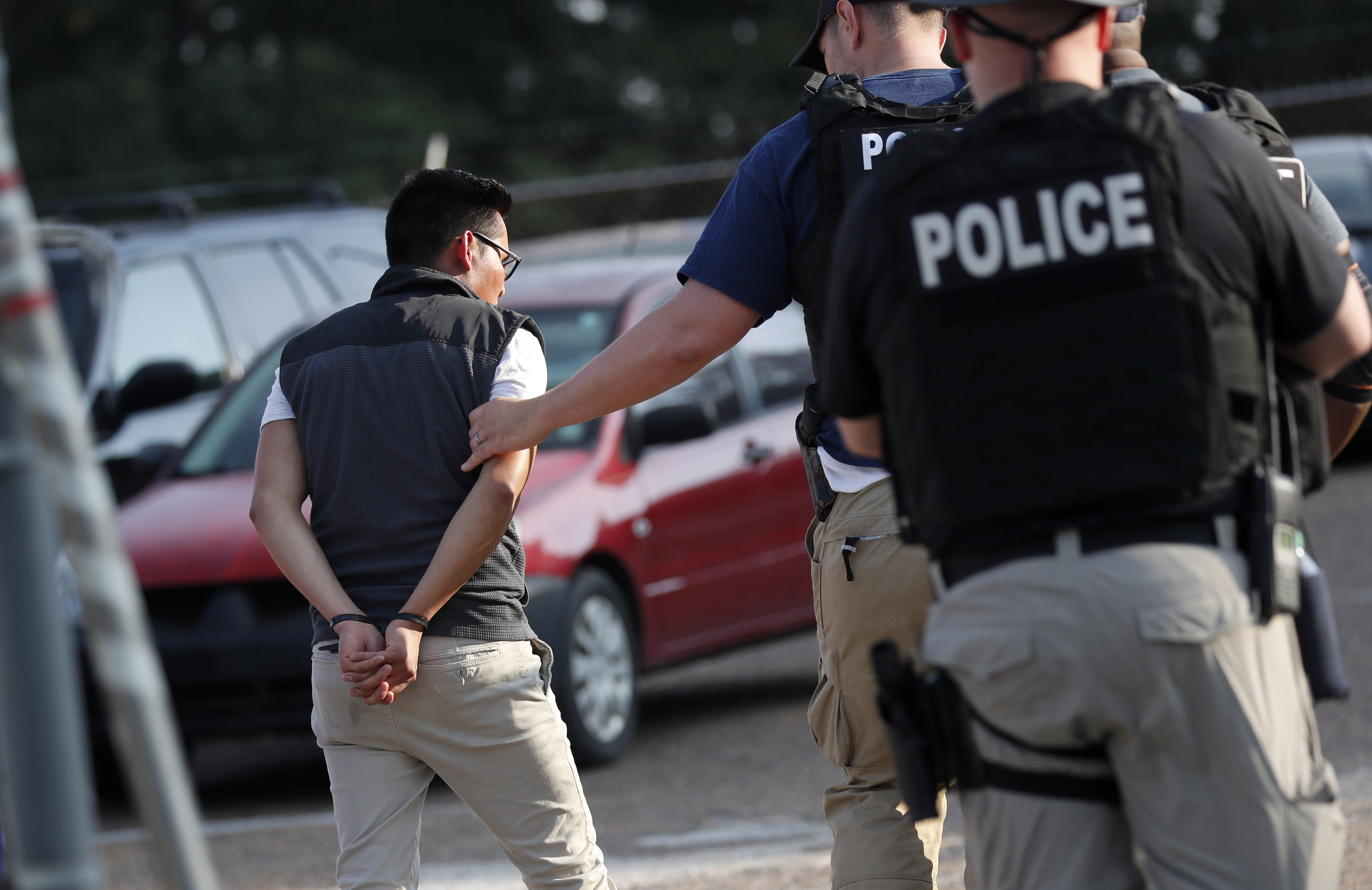 A man is taken into custody at a Koch Foods Inc. plant in Morton, Miss., on August 7, 2019. (Rogelio V. Solis&mdash;AP)