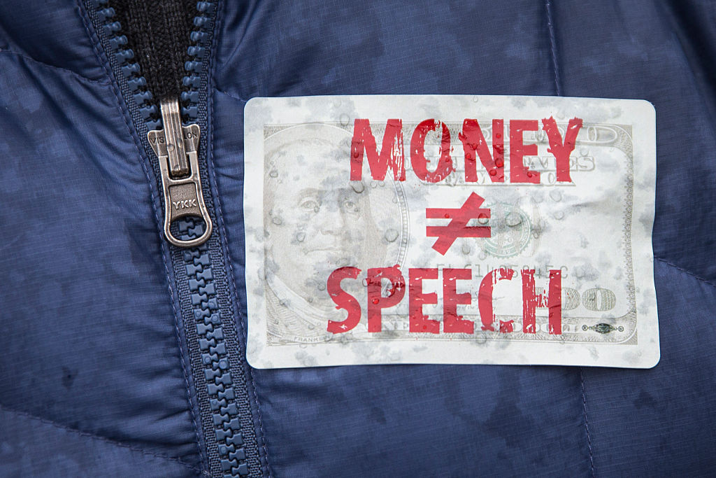 In this file photo, an attendee wears a sticker against money in politics during a rally calling for an end to corporate money in politics and to mark the fifth anniversary of the Supreme Court's Citizens United decision, at Lafayette Square near the White House, January 21, 2015 in Washington, DC. (Drew Angerer—Getty Images)