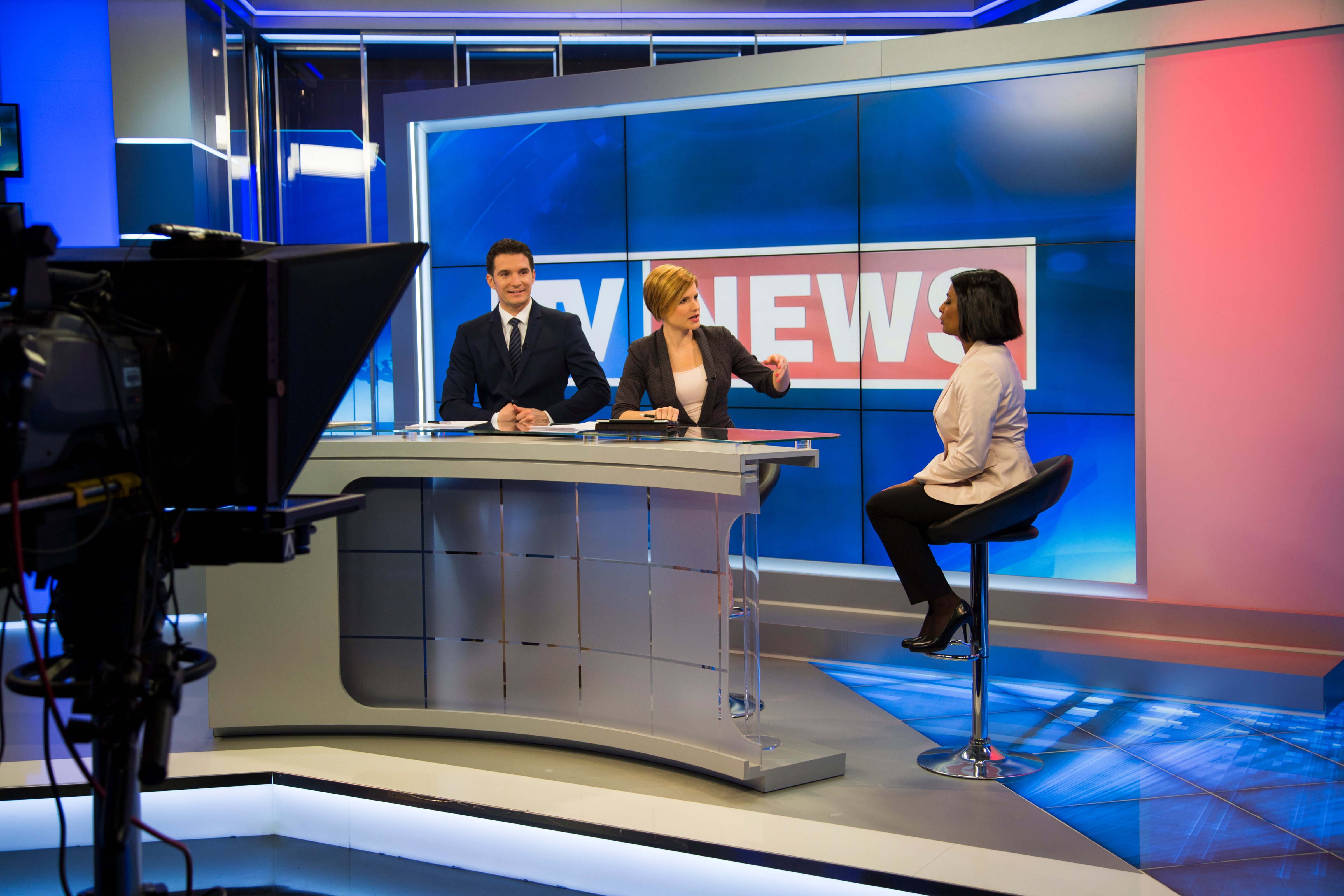 Two commentators preparing for a live interview on the news. Three people in a tv studio talking about the script for the news show. (tomazl&mdash;Getty Images)