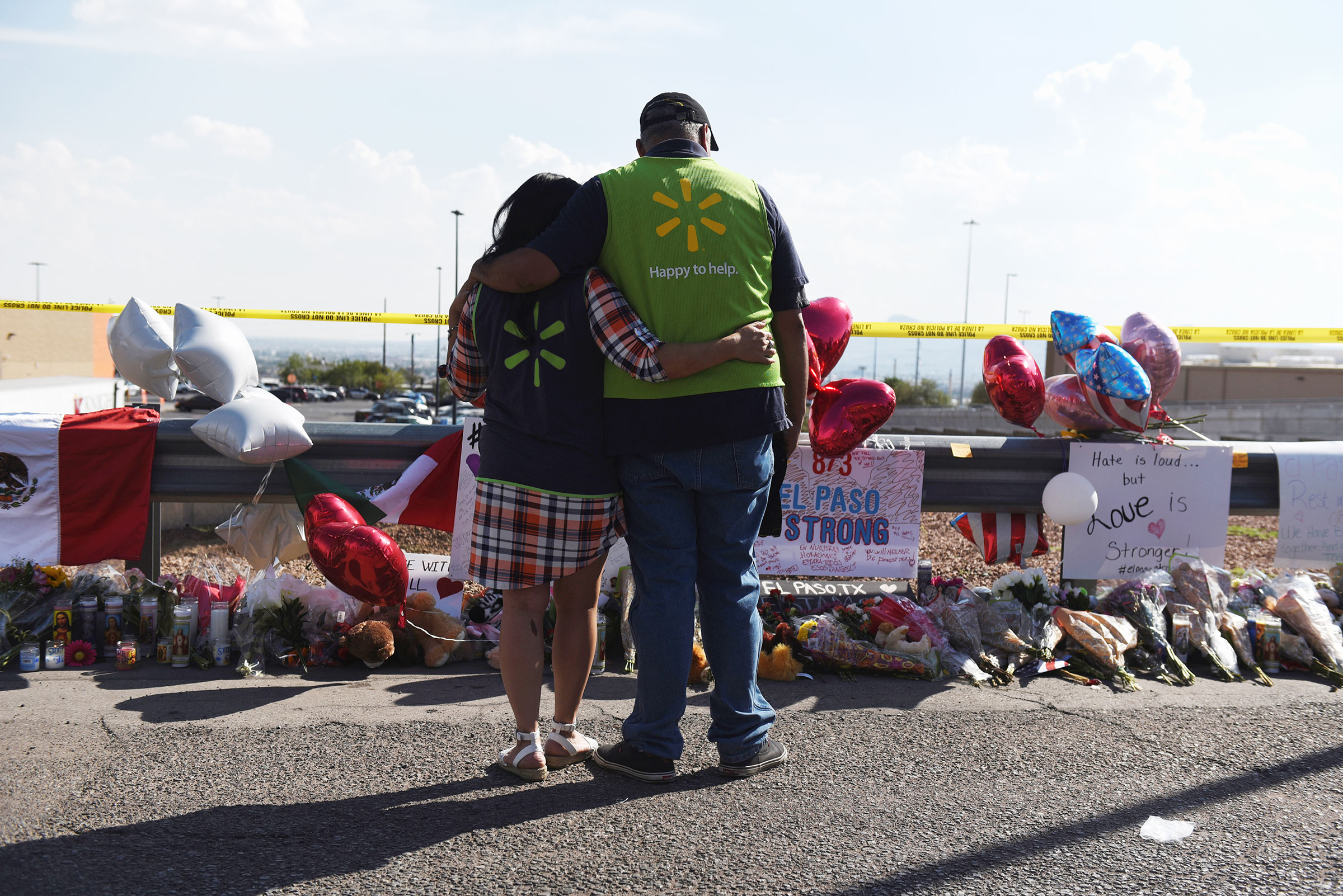 Walmart employees pay their respects at a memorial outside the site of the El Paso mass shooting.