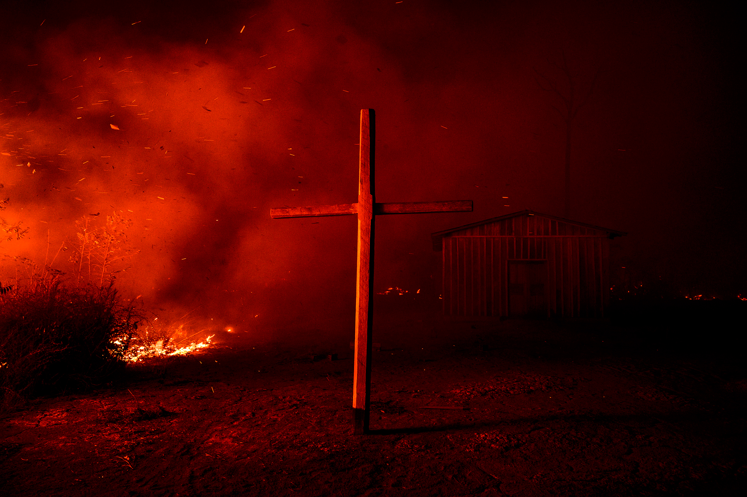 A church is enveloped in smoke from nearby flames in the region of Vila Nova Samuel on Aug. 27. (Sebastián Liste—NOOR for TIME)